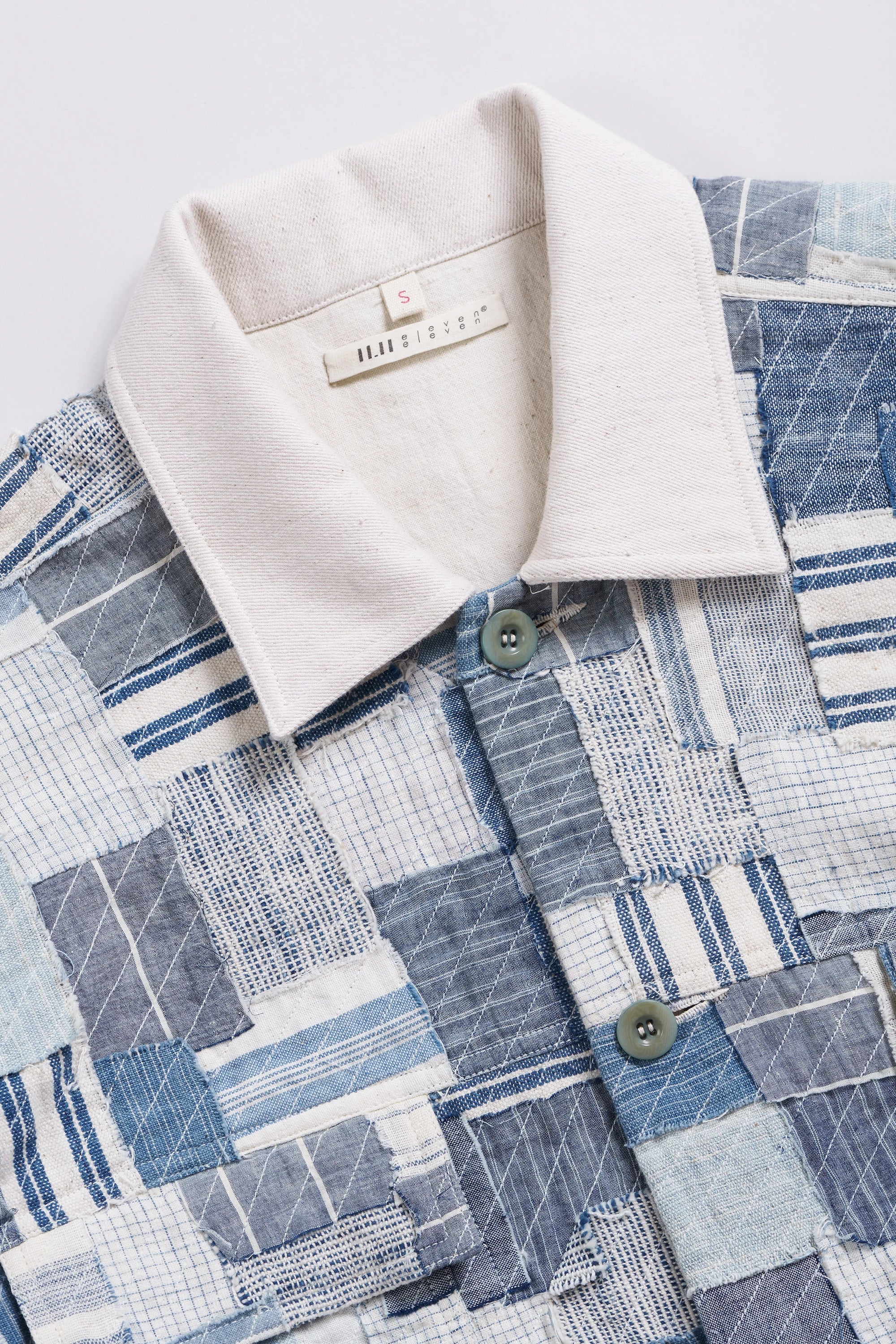 Close-up of a textured fabric with a patterned design and a beige collar.