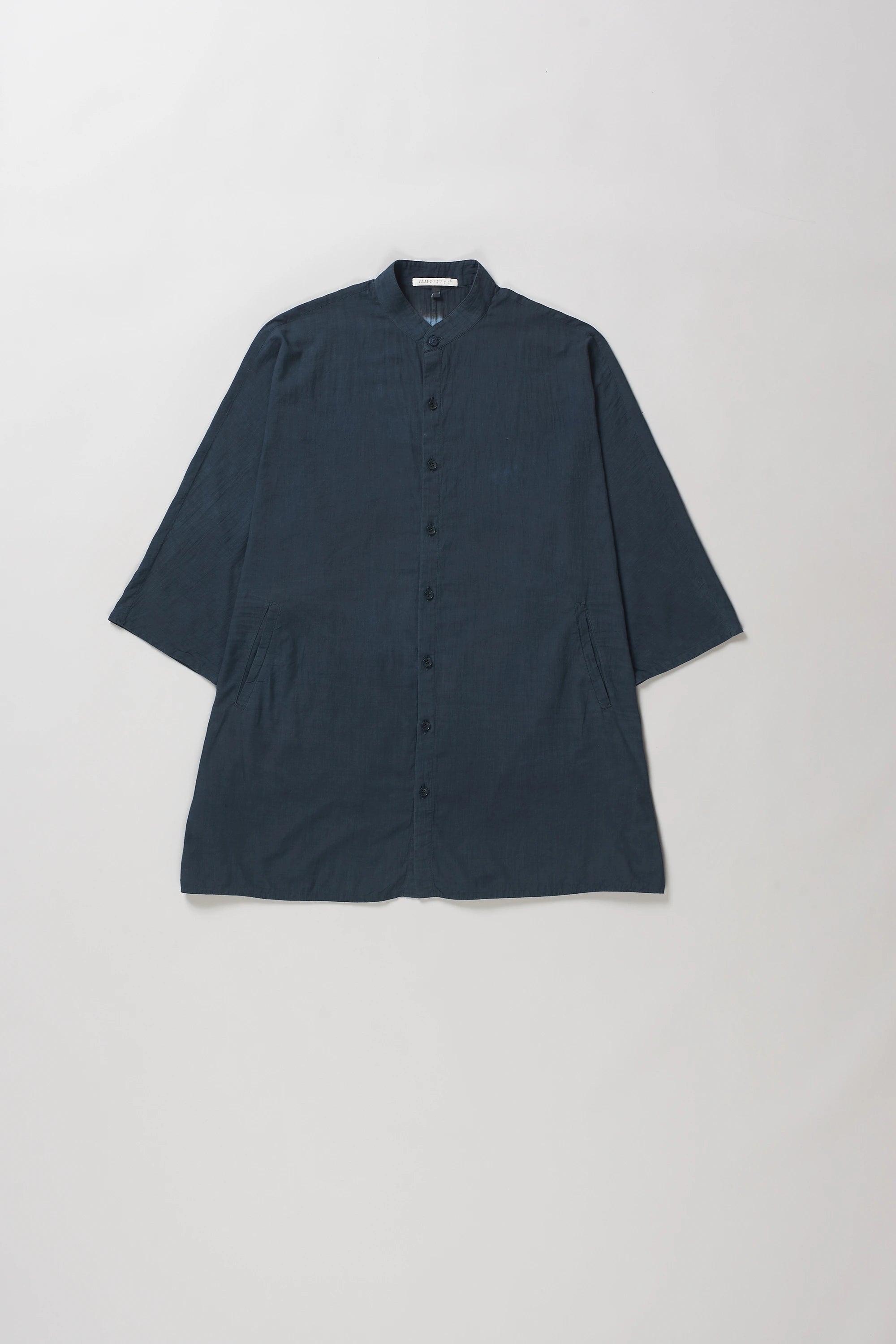 A midnight indigo and tie-dye short-sleeve shirt shown from the back, featuring a solid dark blue border and a lighter blue center with a white dotted pattern.