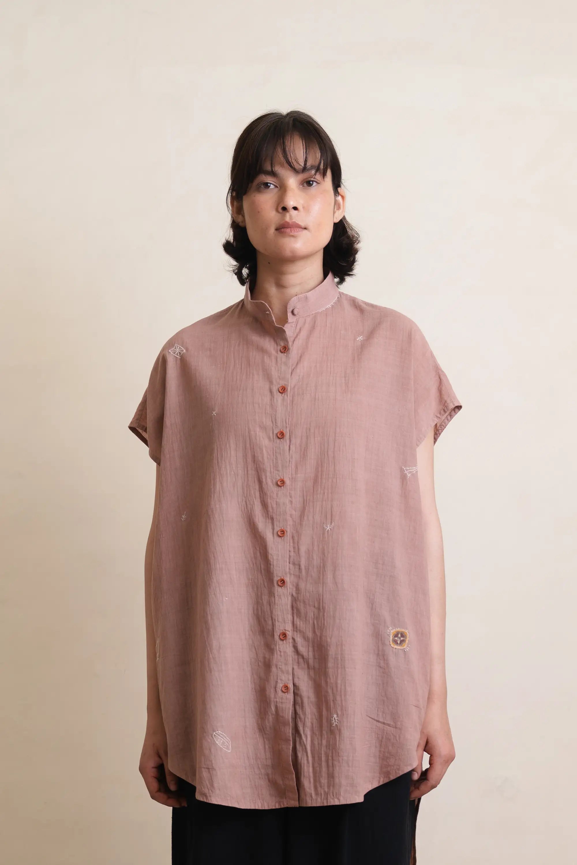 A woman wearing old rose cotton shirt