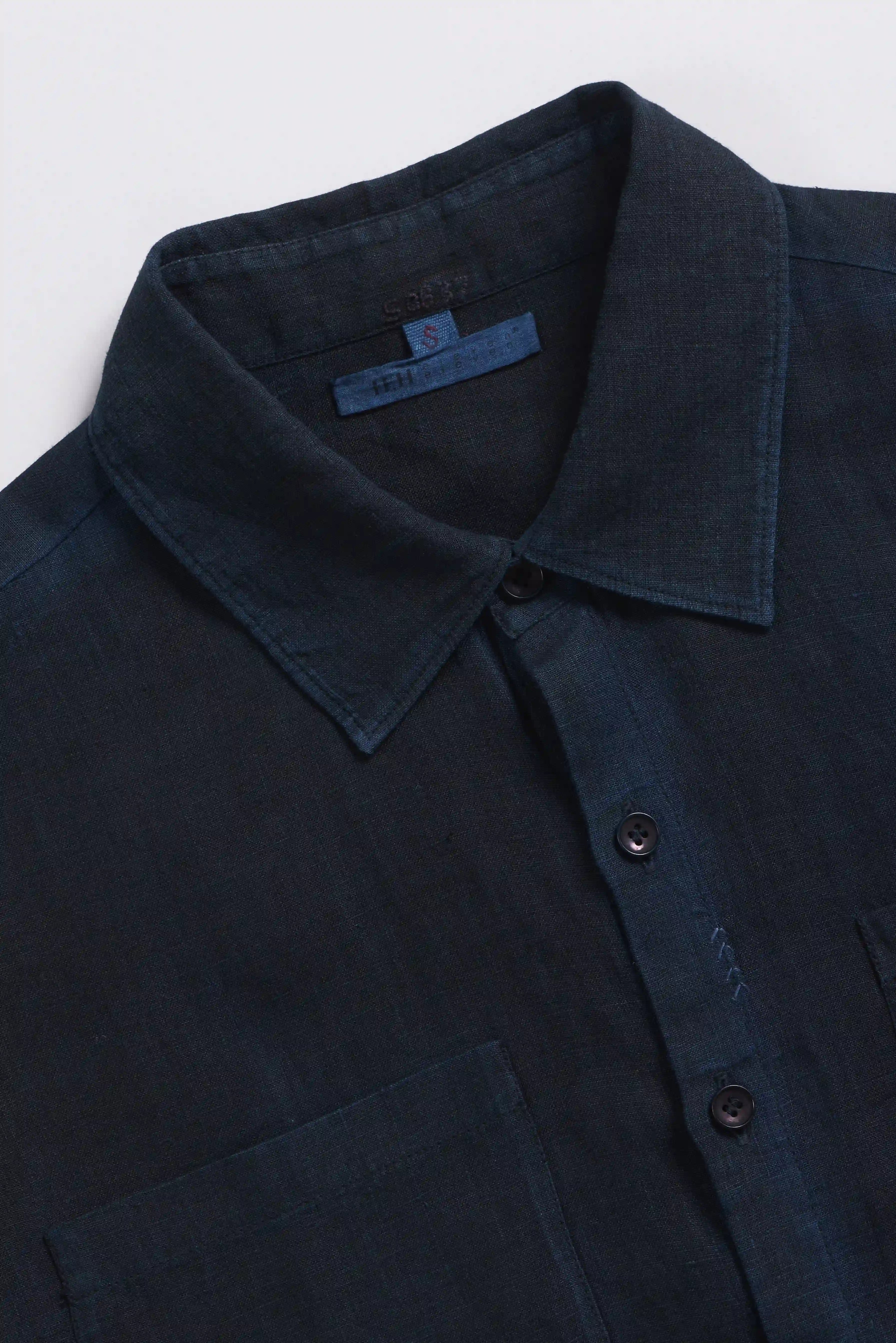 Close-up of a black shirt with collar and buttons on a white background
