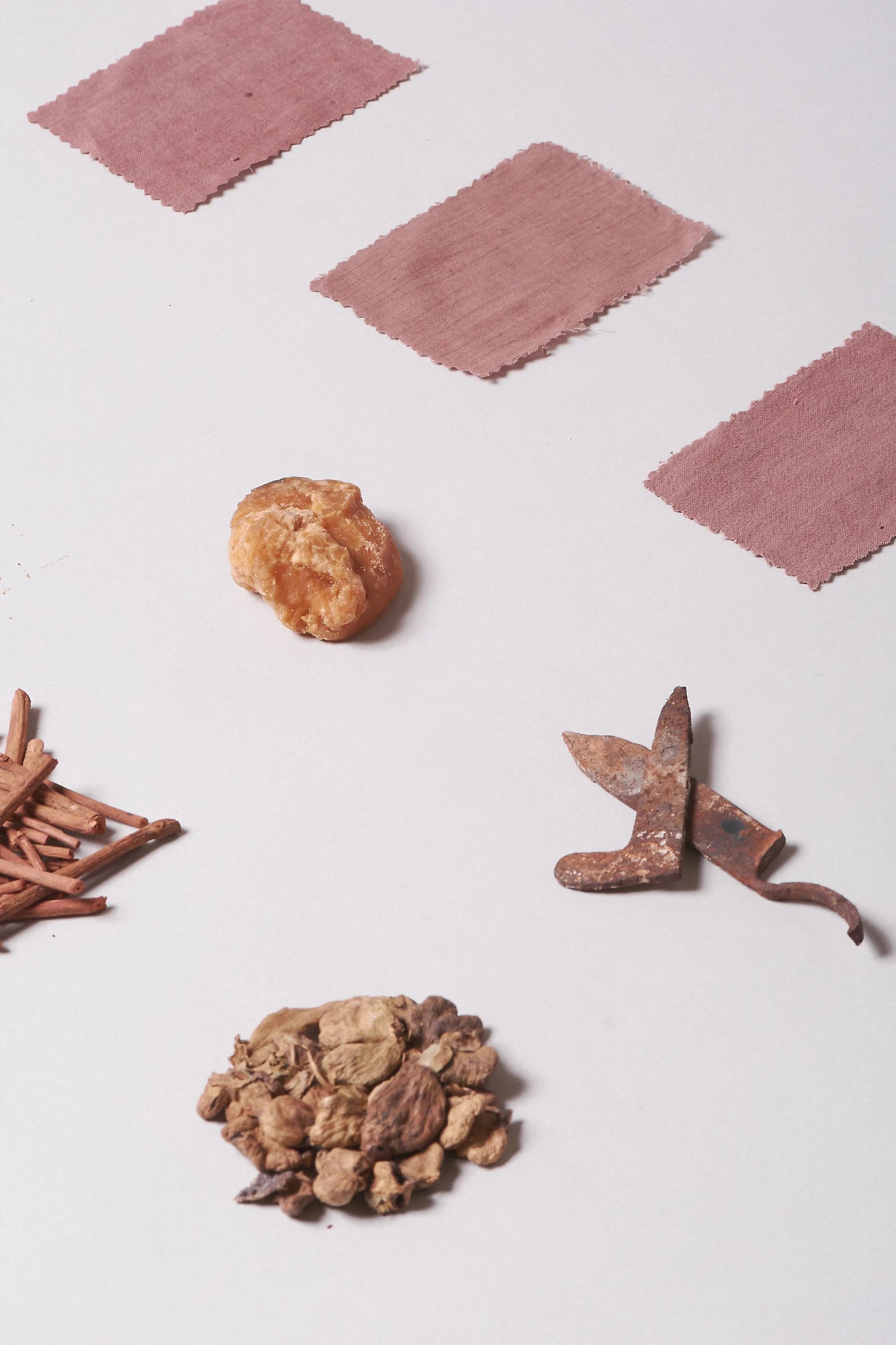 Spices and herbs on a white surface with pink fabric swatches