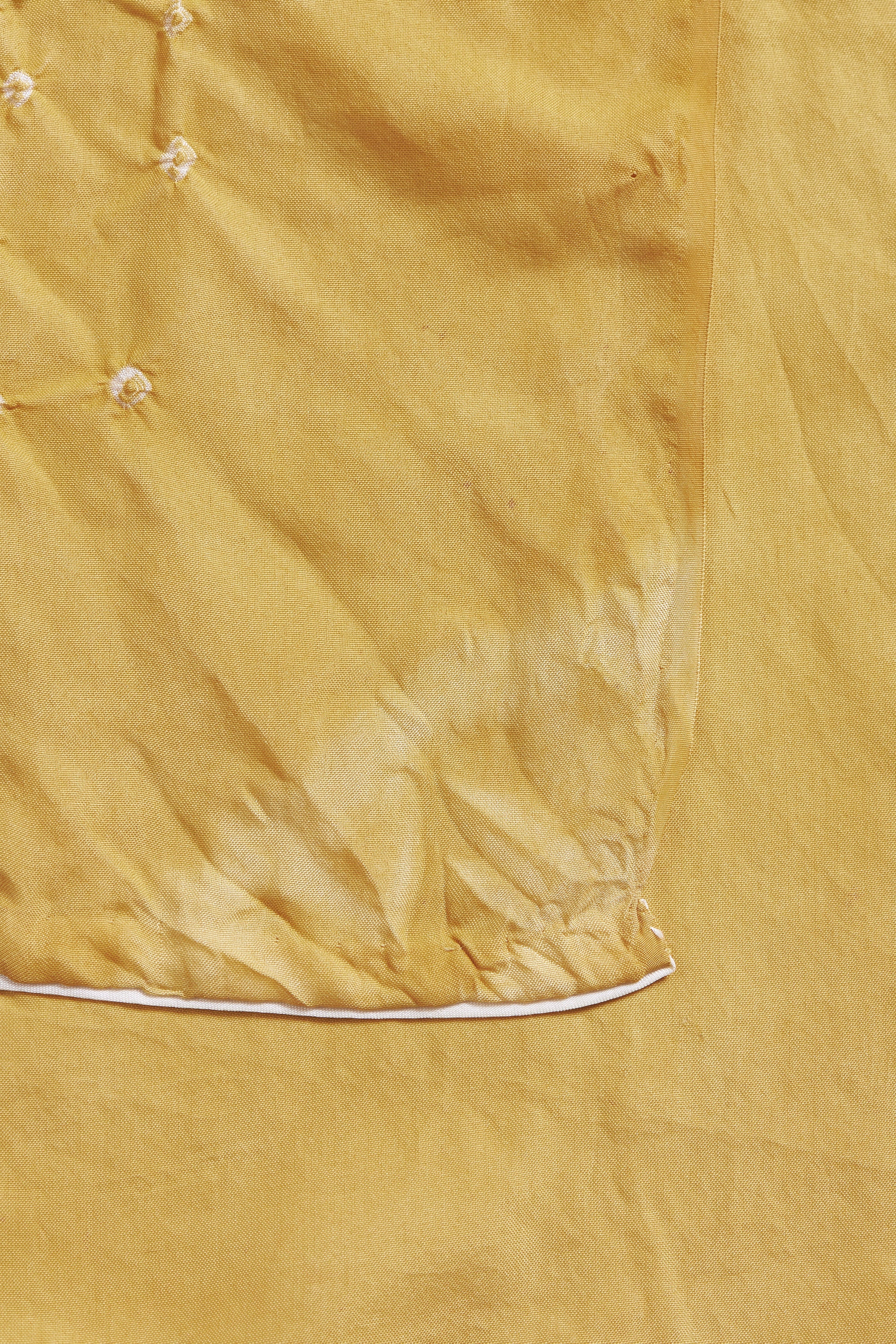 Close-up of a mustard yellow fabric with a subtle pattern