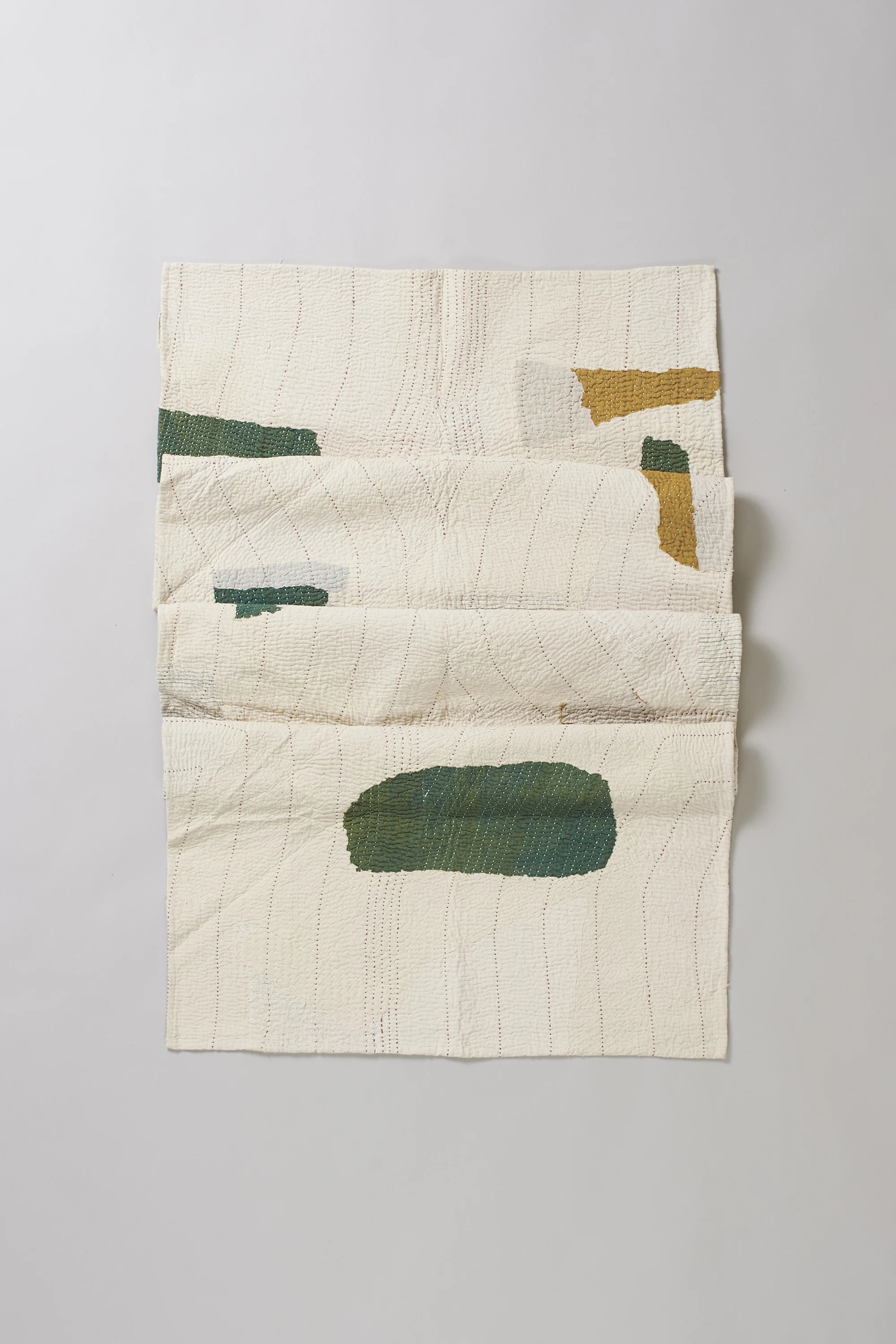 Ecru cotton quilt on light grey back ground
