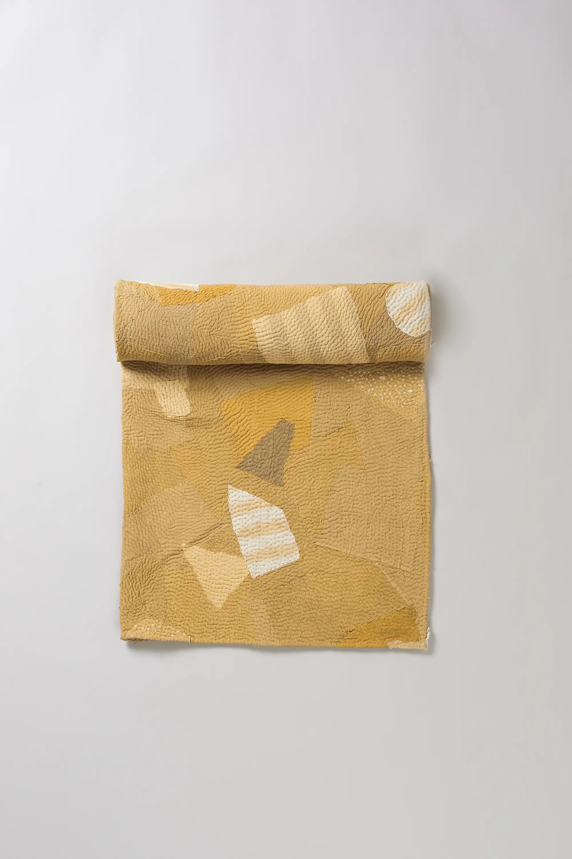 Yellow quilt roll on a light grey background