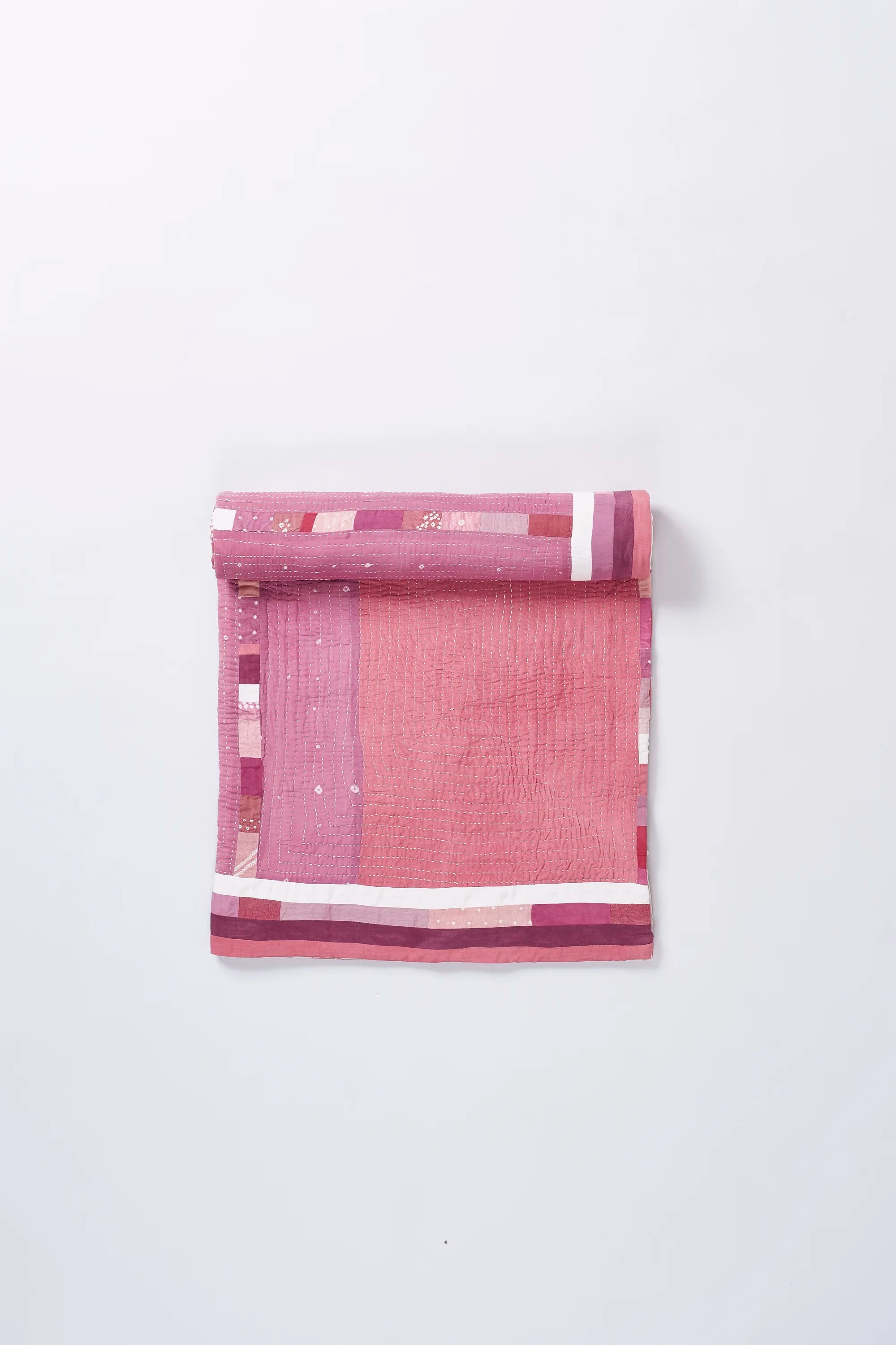 Colourfull quilt roll on a light grey background