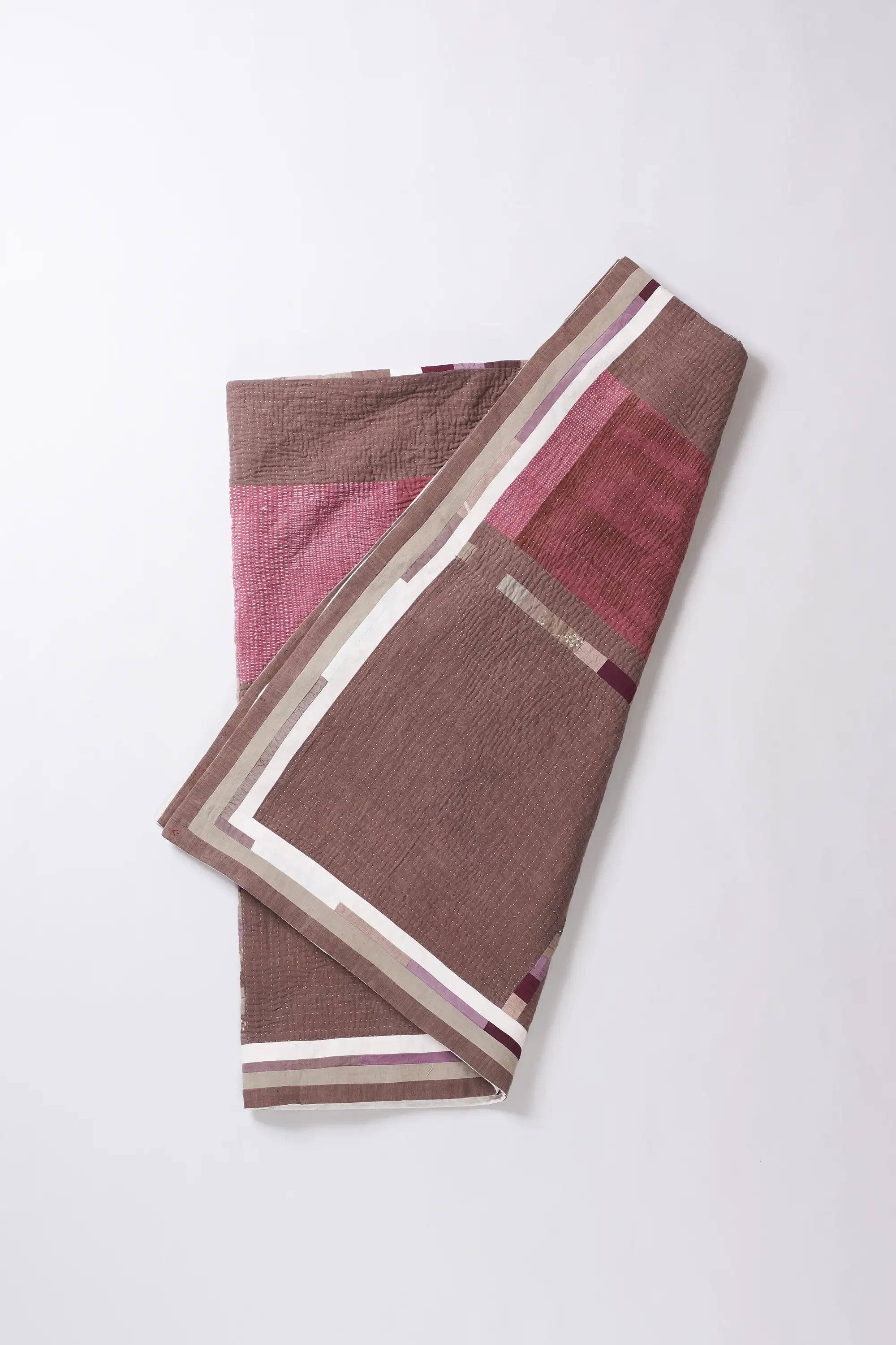 Folded fabric with pink and wine pattern on a white background