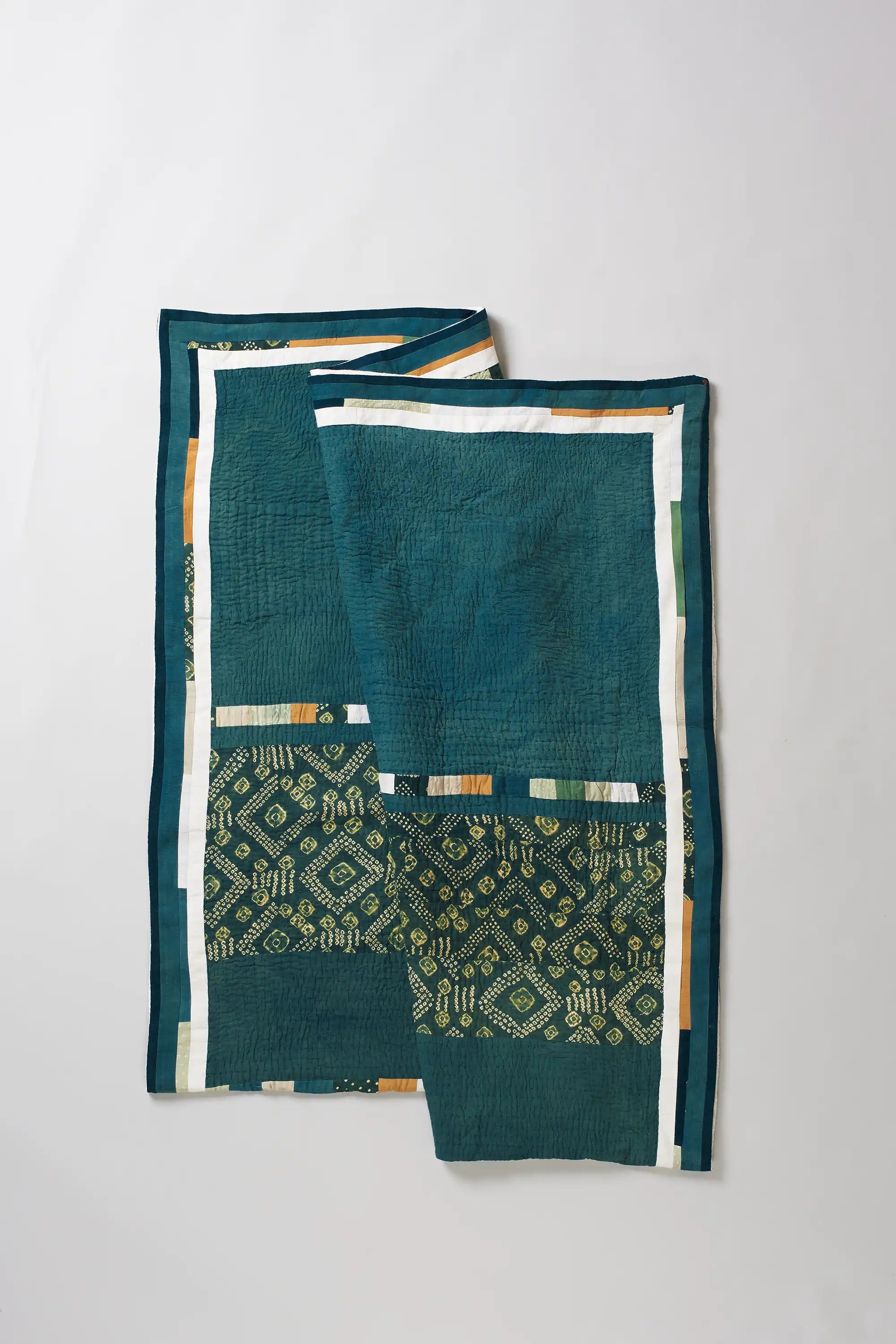 Folded turf green quilt on light grey background