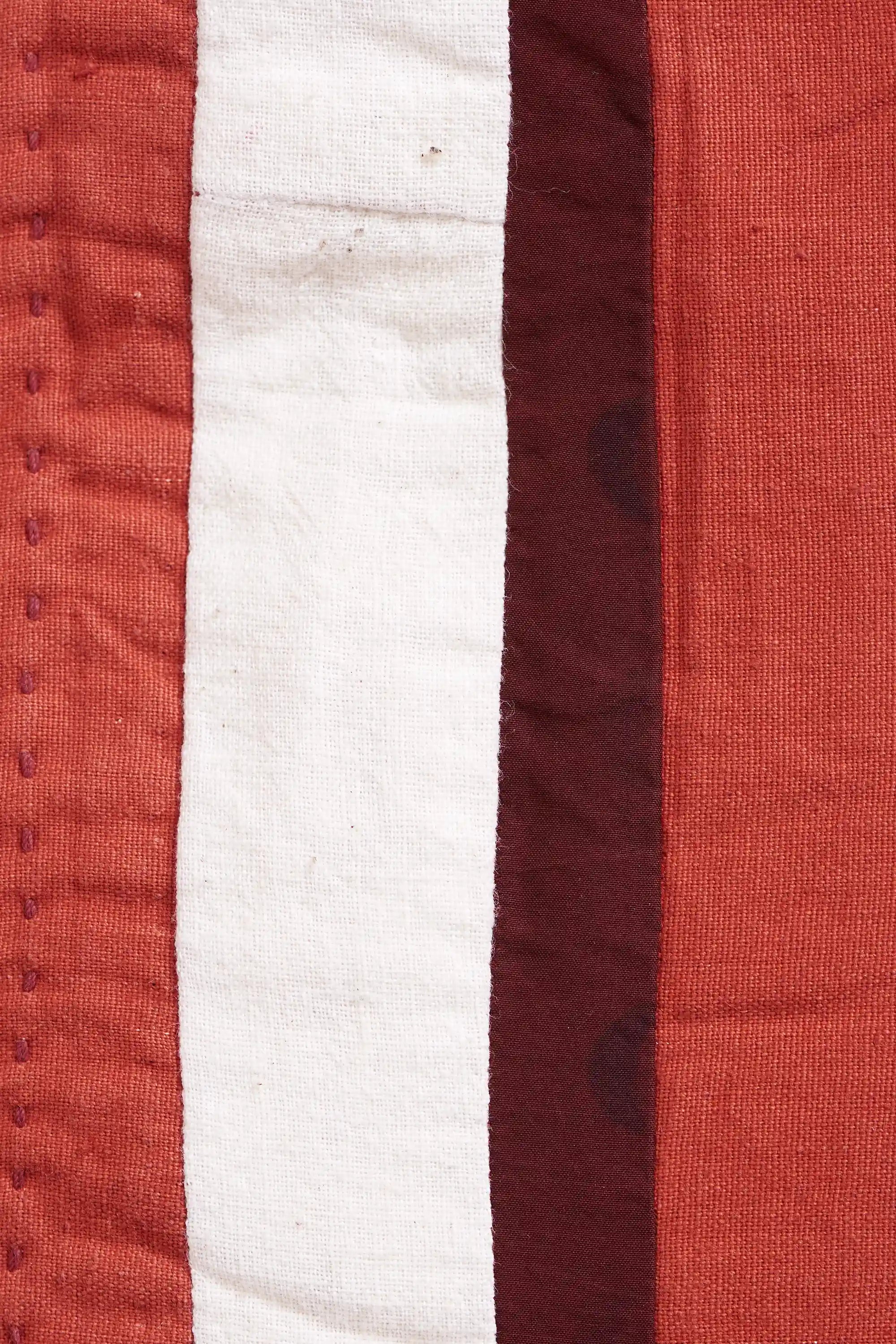 Close-up of a quilt with red and white stripes.