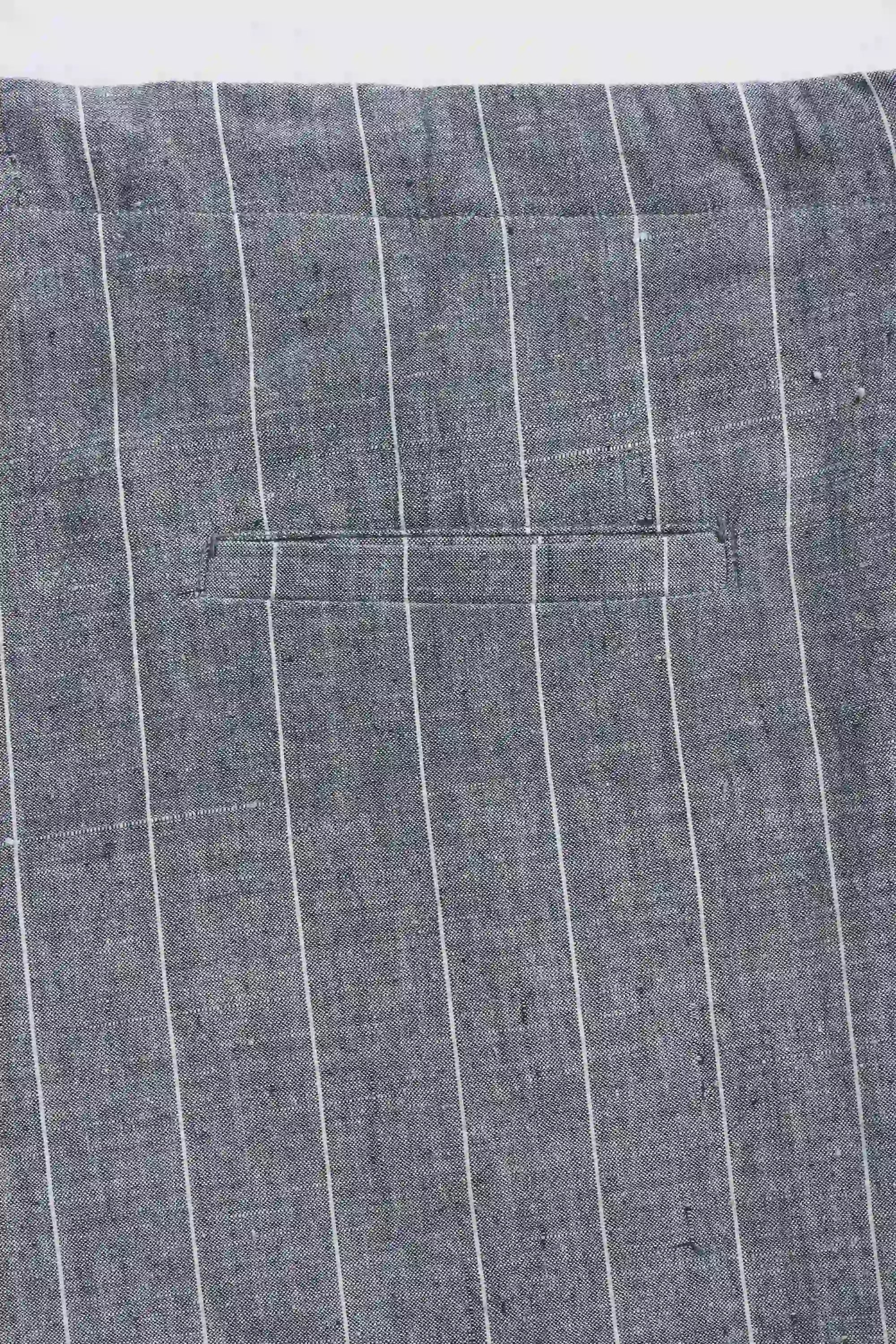 Close-up of grey fabric with a pocket detail on a white background