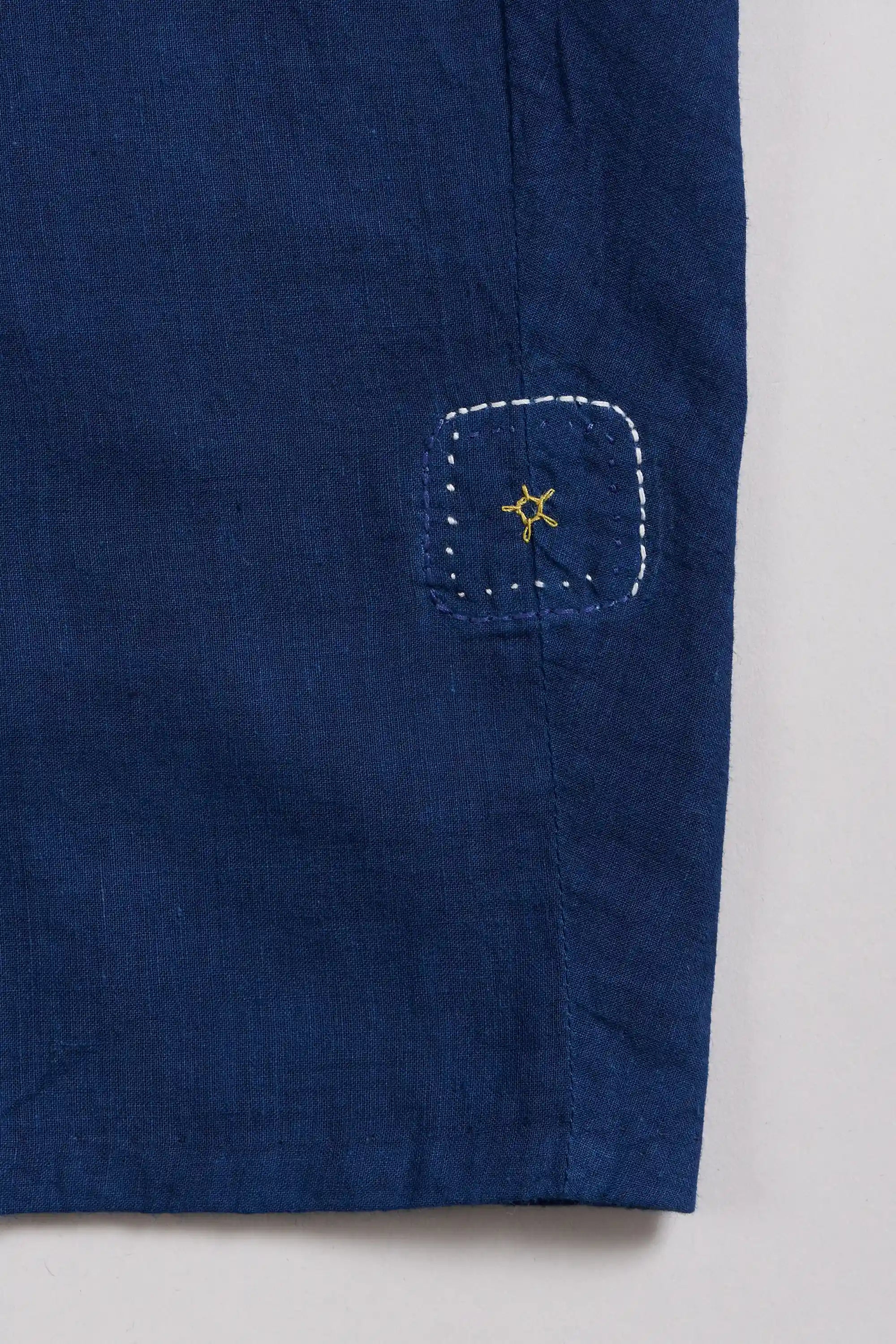Close-up of a blue fabric  with a pehchanbox on a light grey background