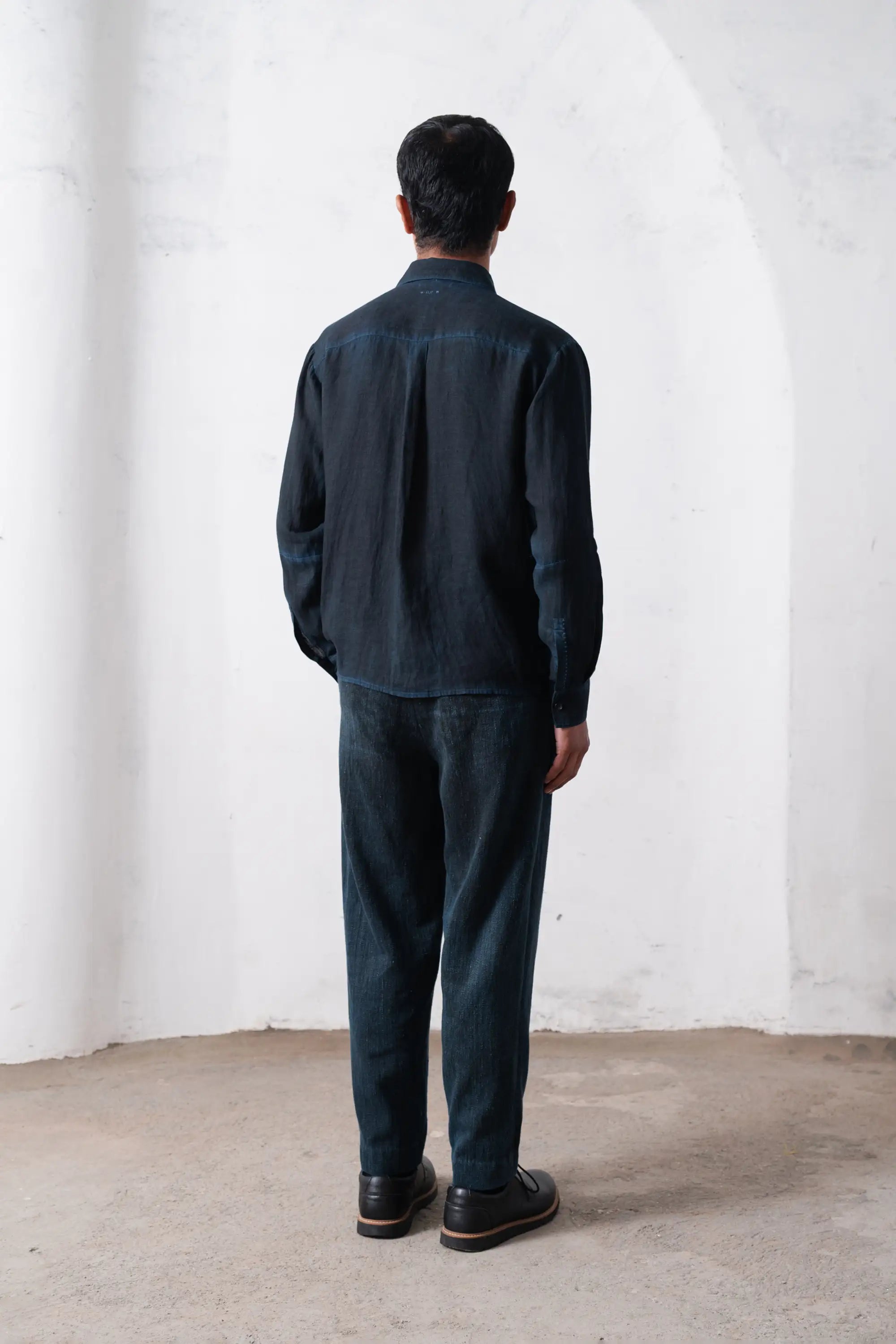 A back shot of a man wearing shirt in black