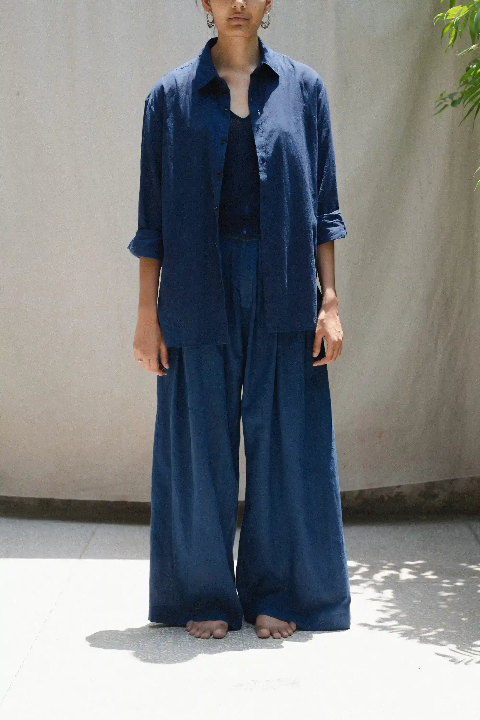 Person wearing a blue outfit standing against a plain background