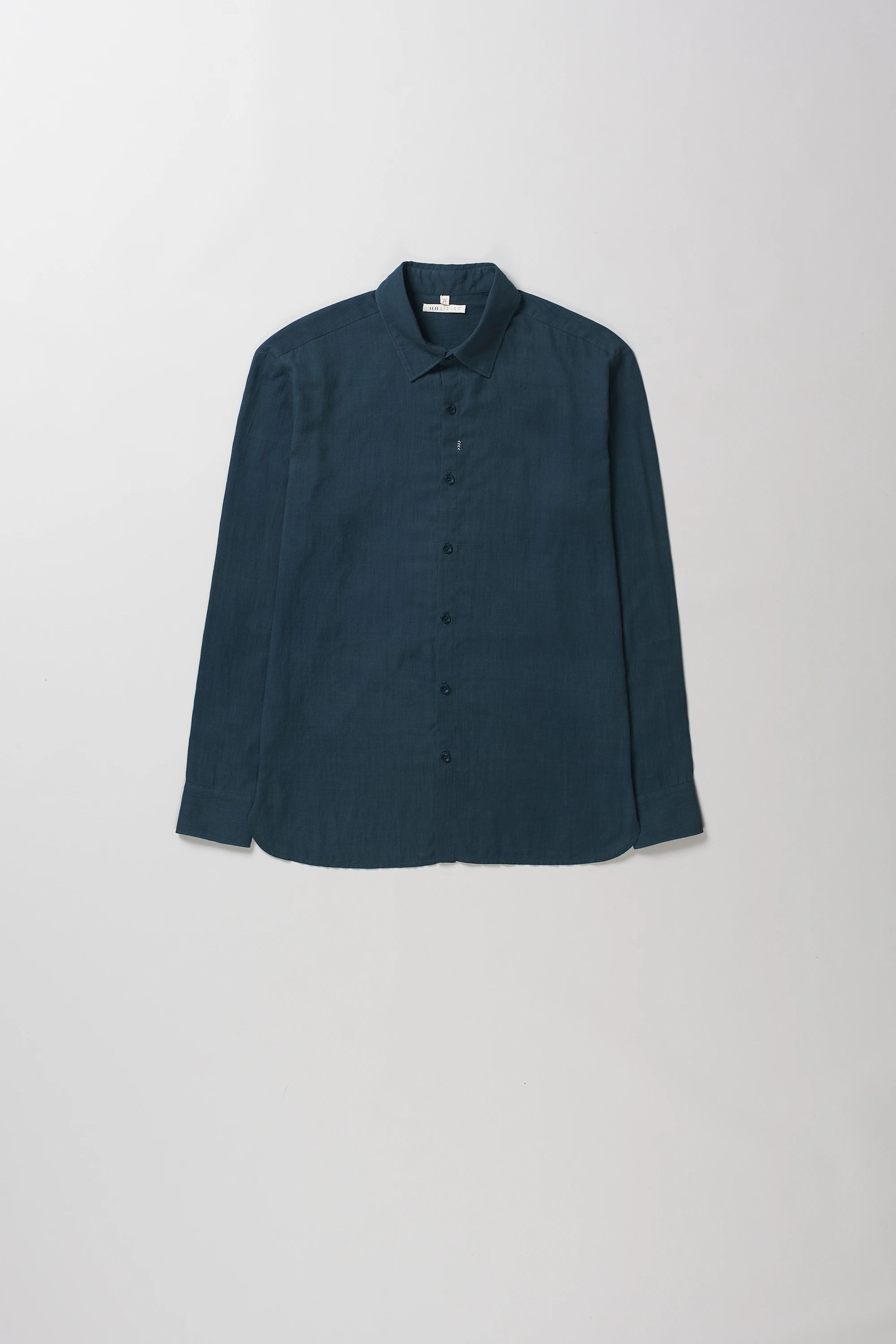 Black indigo long-sleeve button-up shirt with a pointed collar, laid flat against a light gray background.