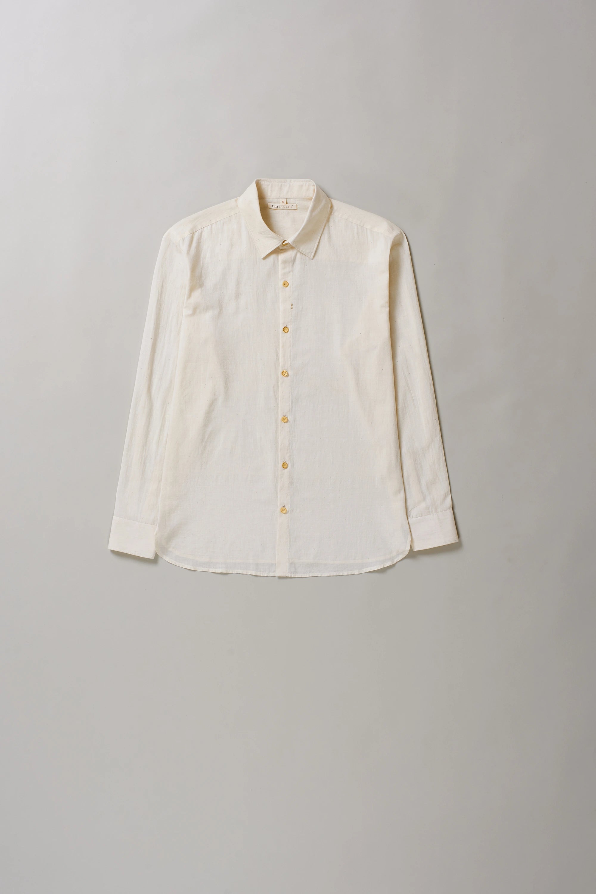 Front image of ecru cotton shirt on a grey background