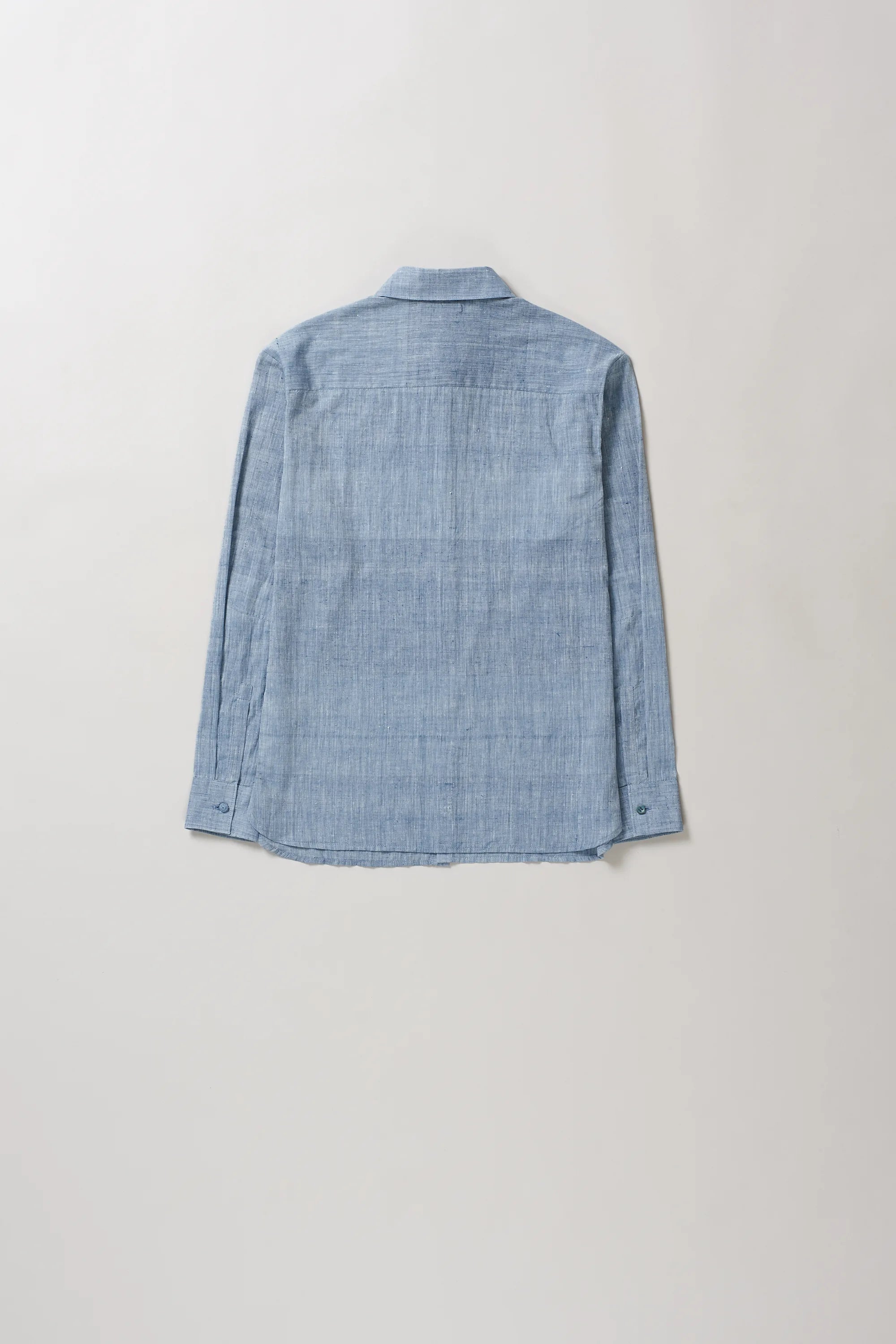 Back image of blue shirt on a light grey background