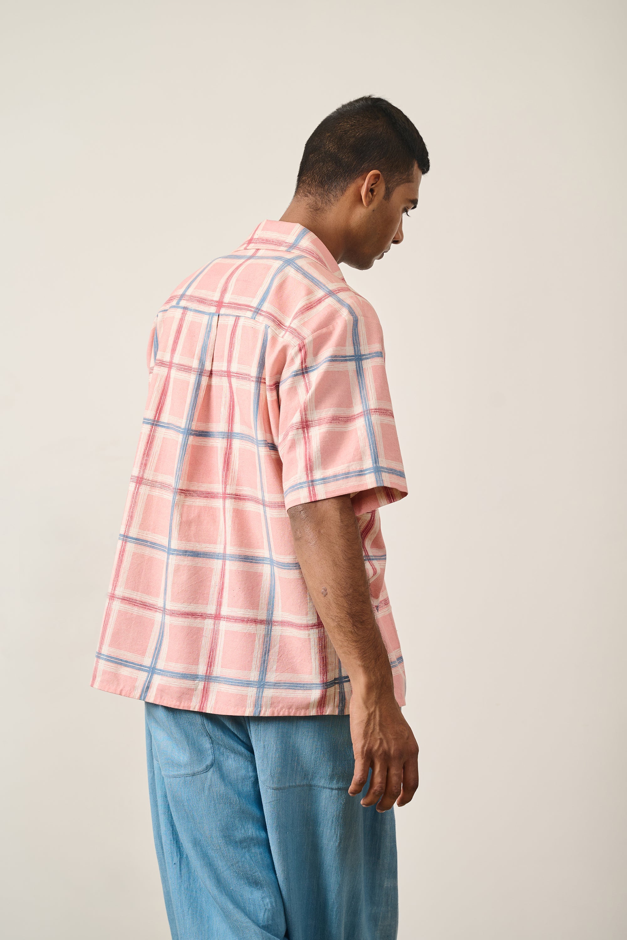 A back shot of a man wearing multi colour cotton checked shirt