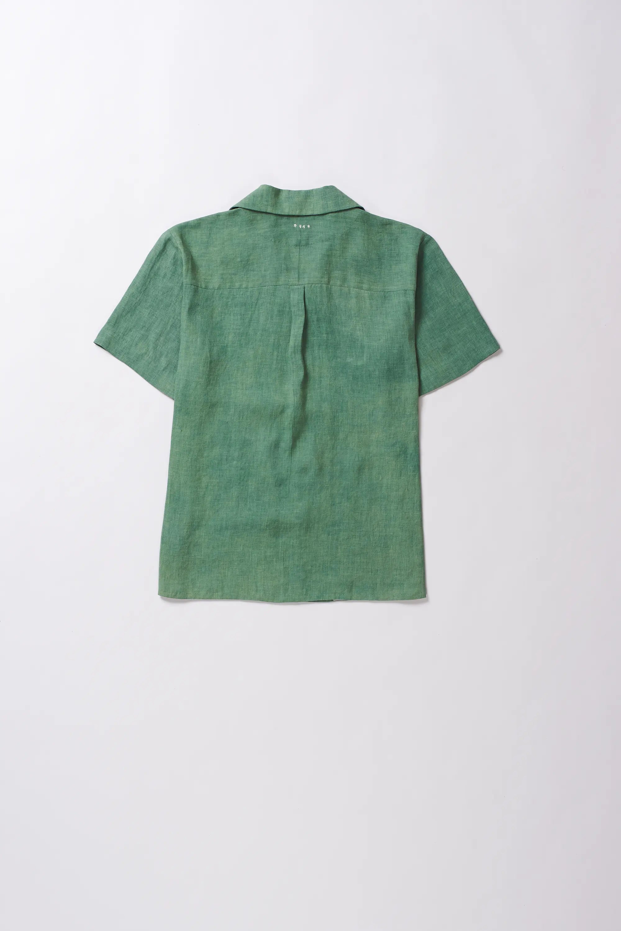 Green linen shirt on a light grey background