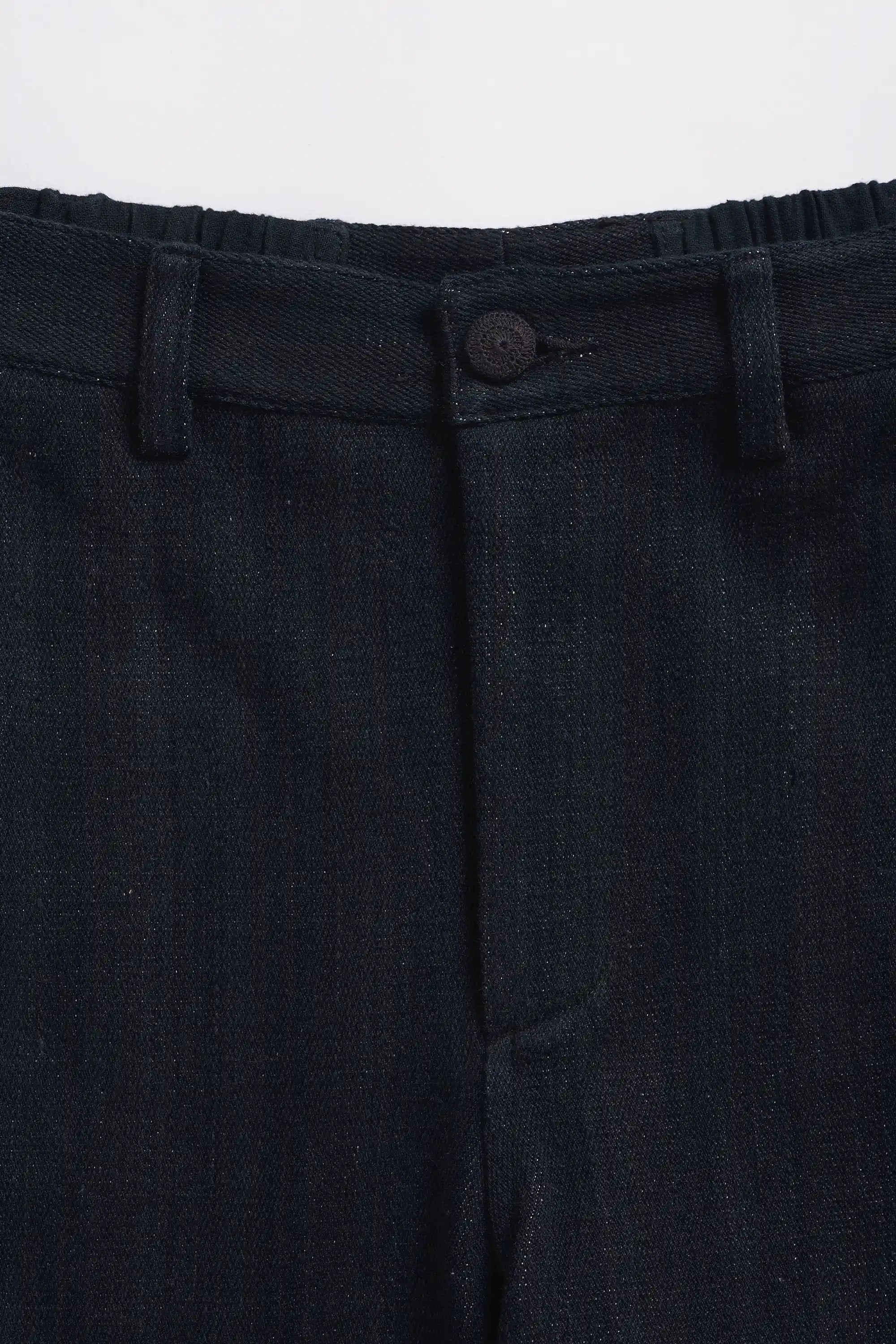 Close-up of dark blue pants with a button on a light grey background