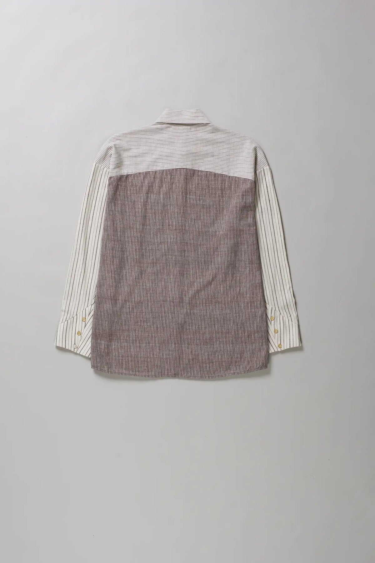 A long-sleeve shirt shown from the back, featuring a solid taupe-brown textured back panel and cream vertical-striped sleeves, laid flat against a neutral grey background.