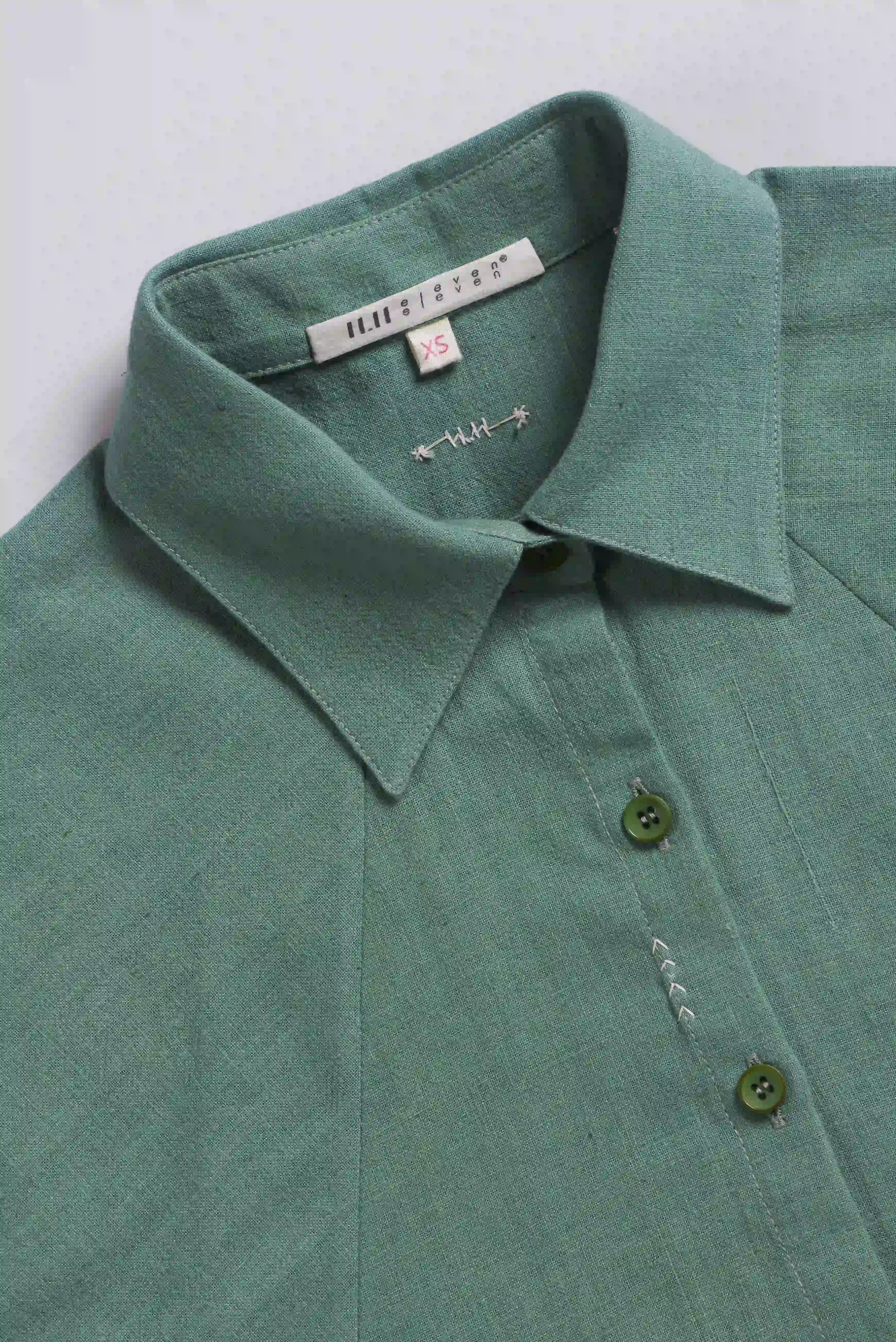 Green shirt with collar and buttons on a light grey background