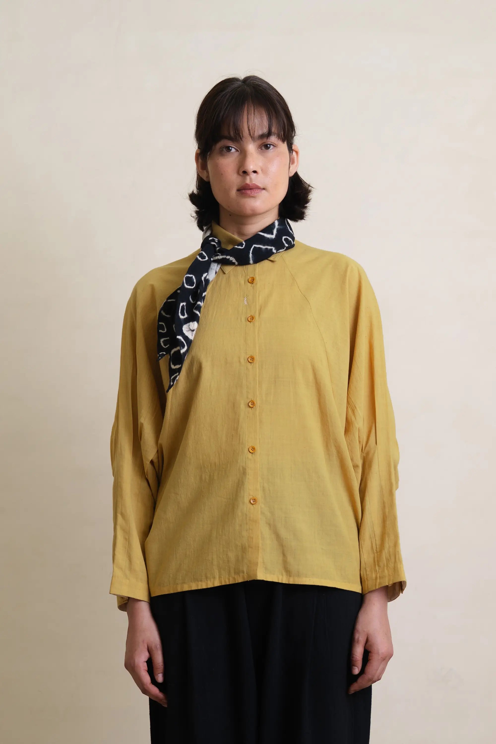 A woman wearing ochre yellow cotton shirt
