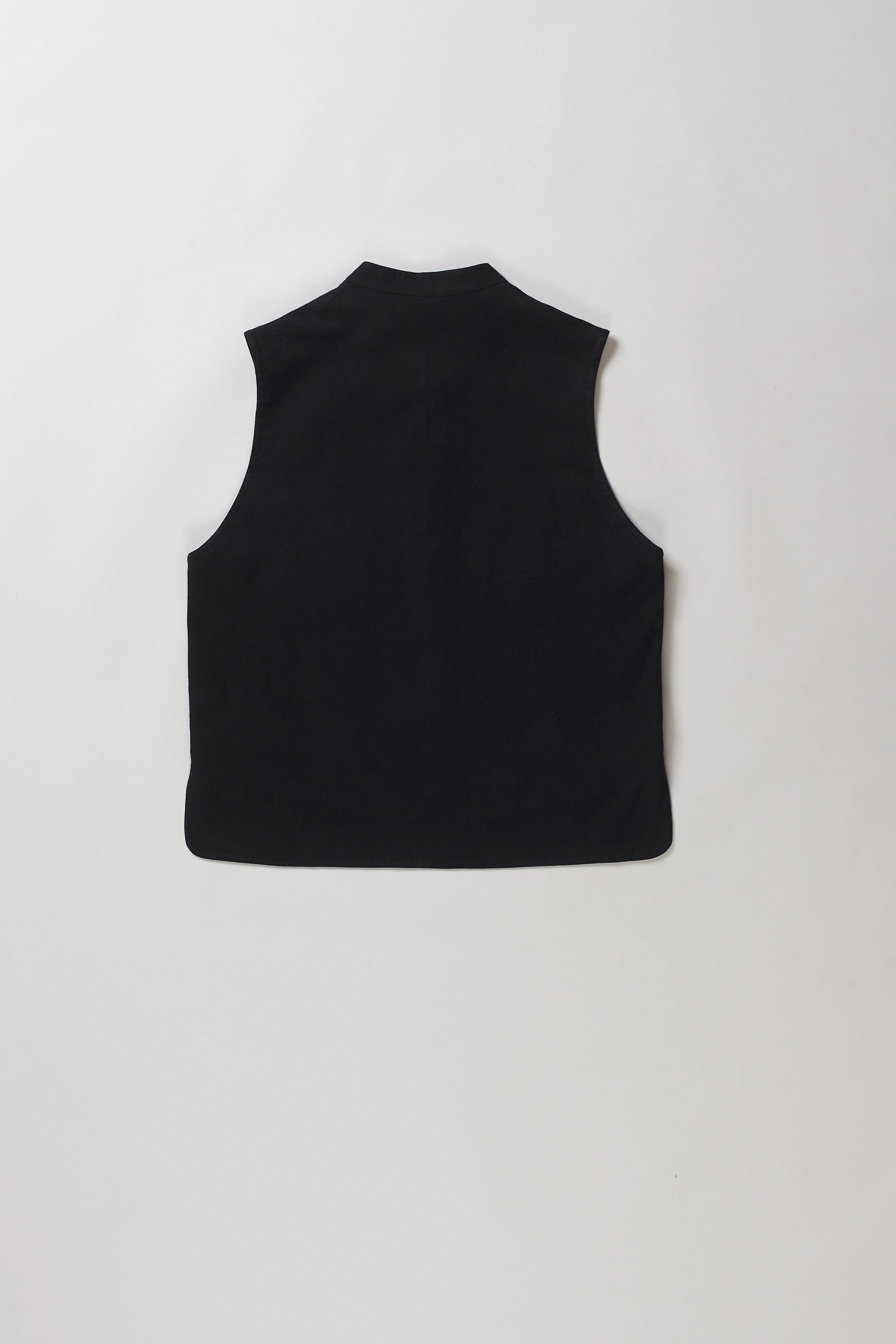 Back shot of black sleeveless vest with a mandarin collar and front button closure, laid flat against a light grey background.