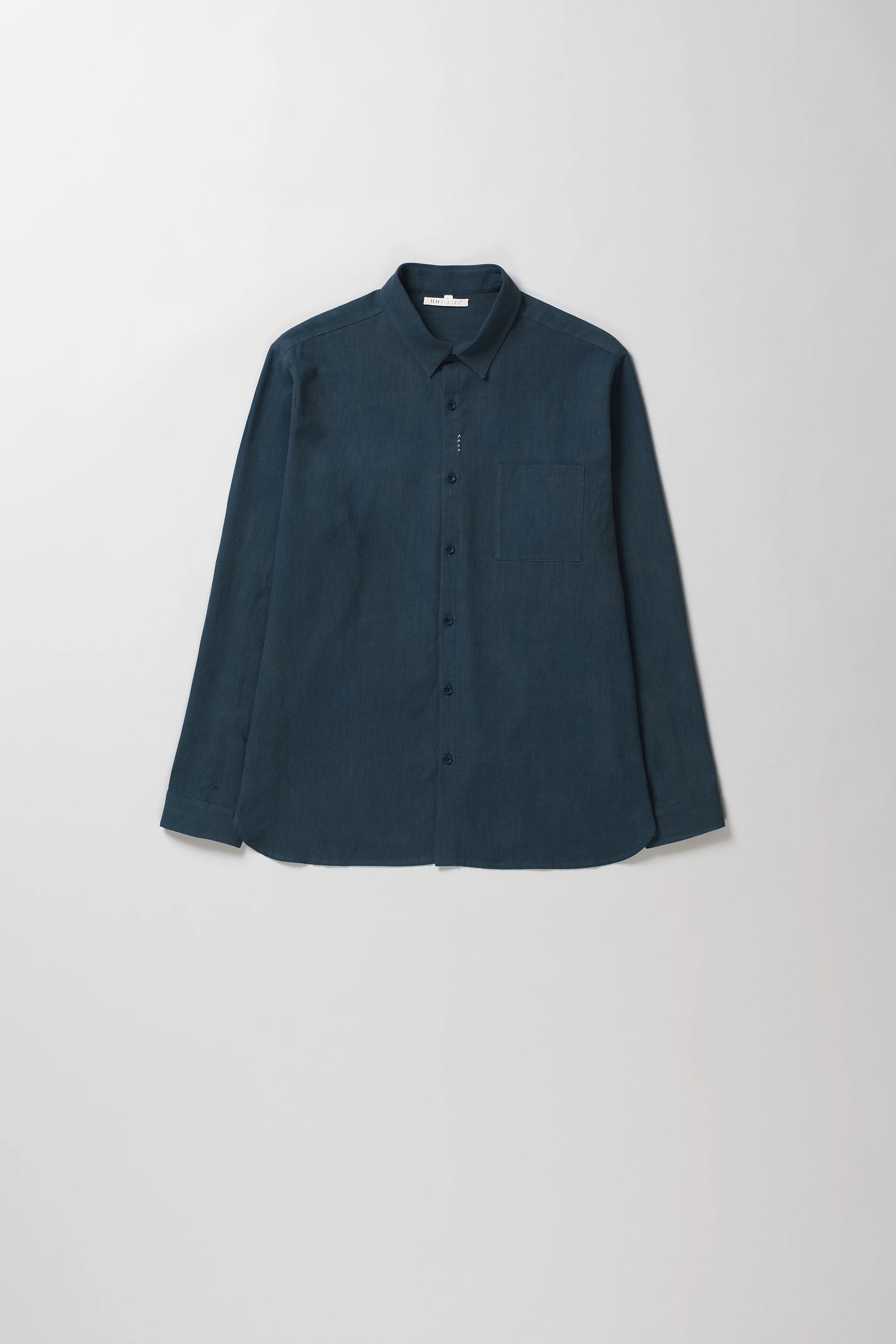 Black indigo long-sleeve button-up shirt with a pointed collar, laid flat against a light gray background.