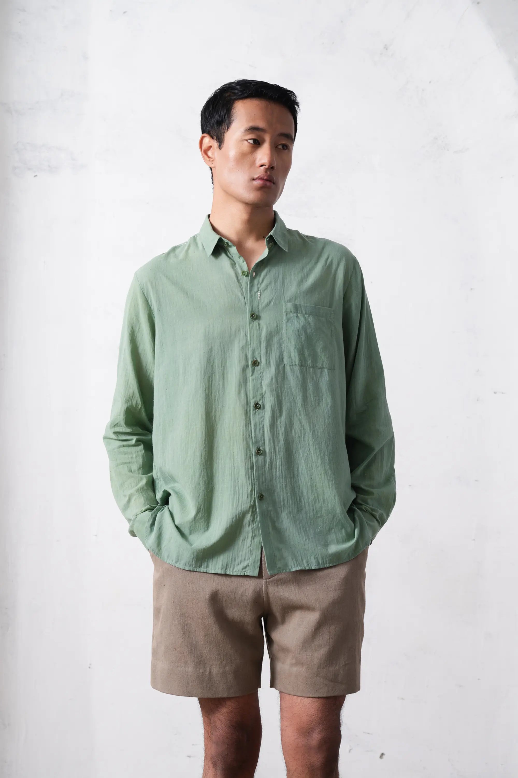 A man wearing turf green cotton shirt