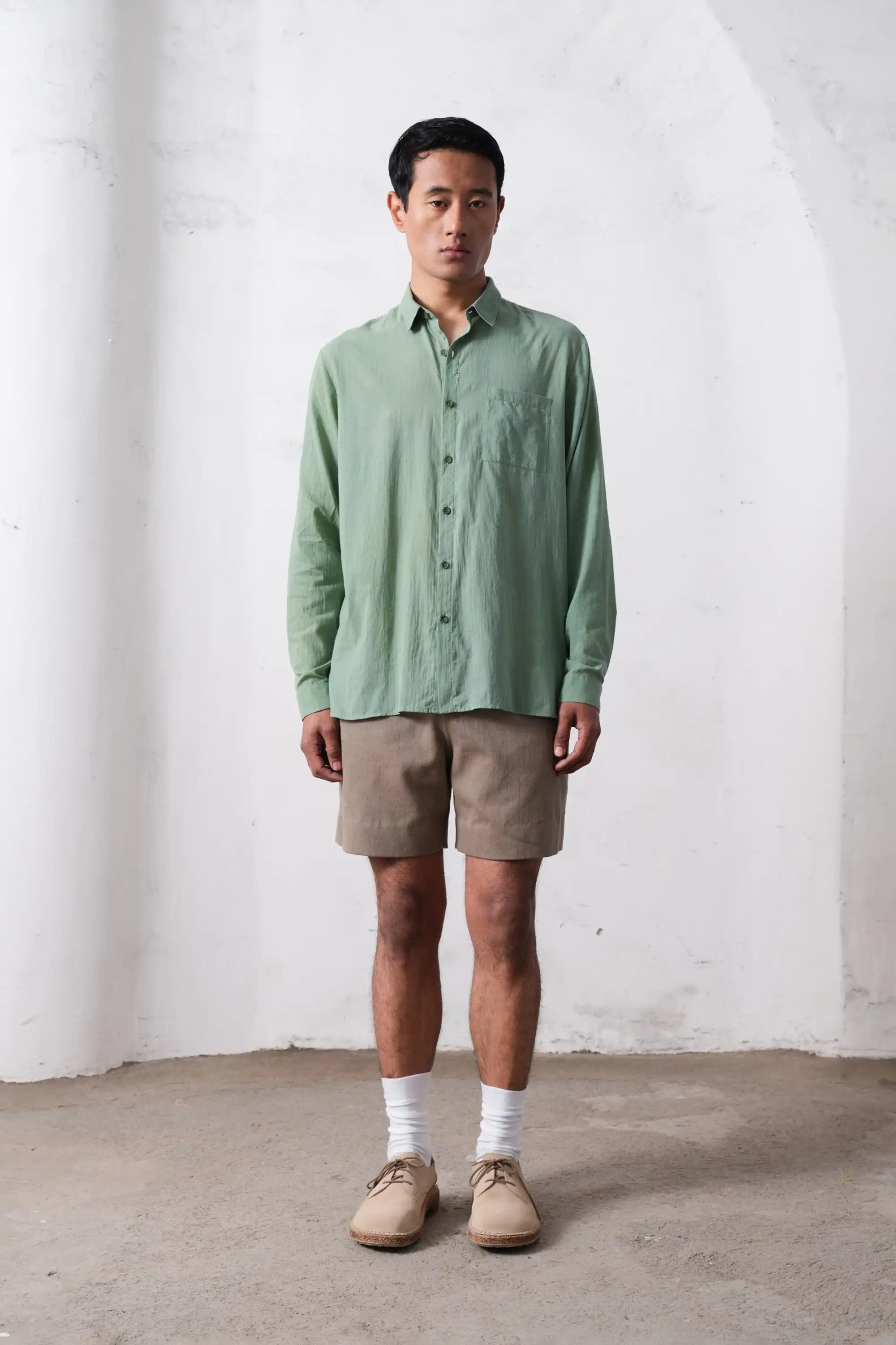 A man wearing turf green shirt