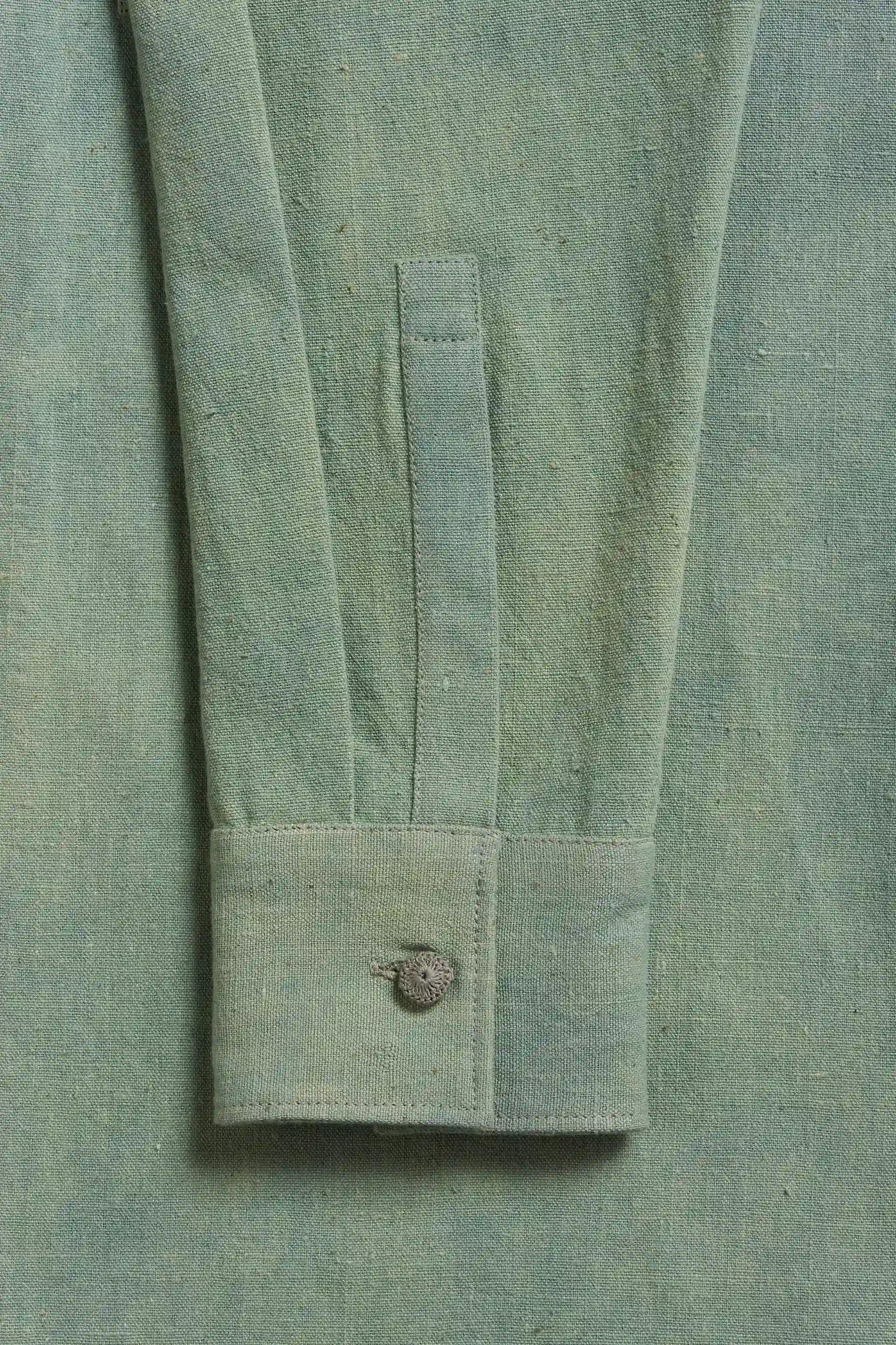 Close-up of a turf green shirt with a button 