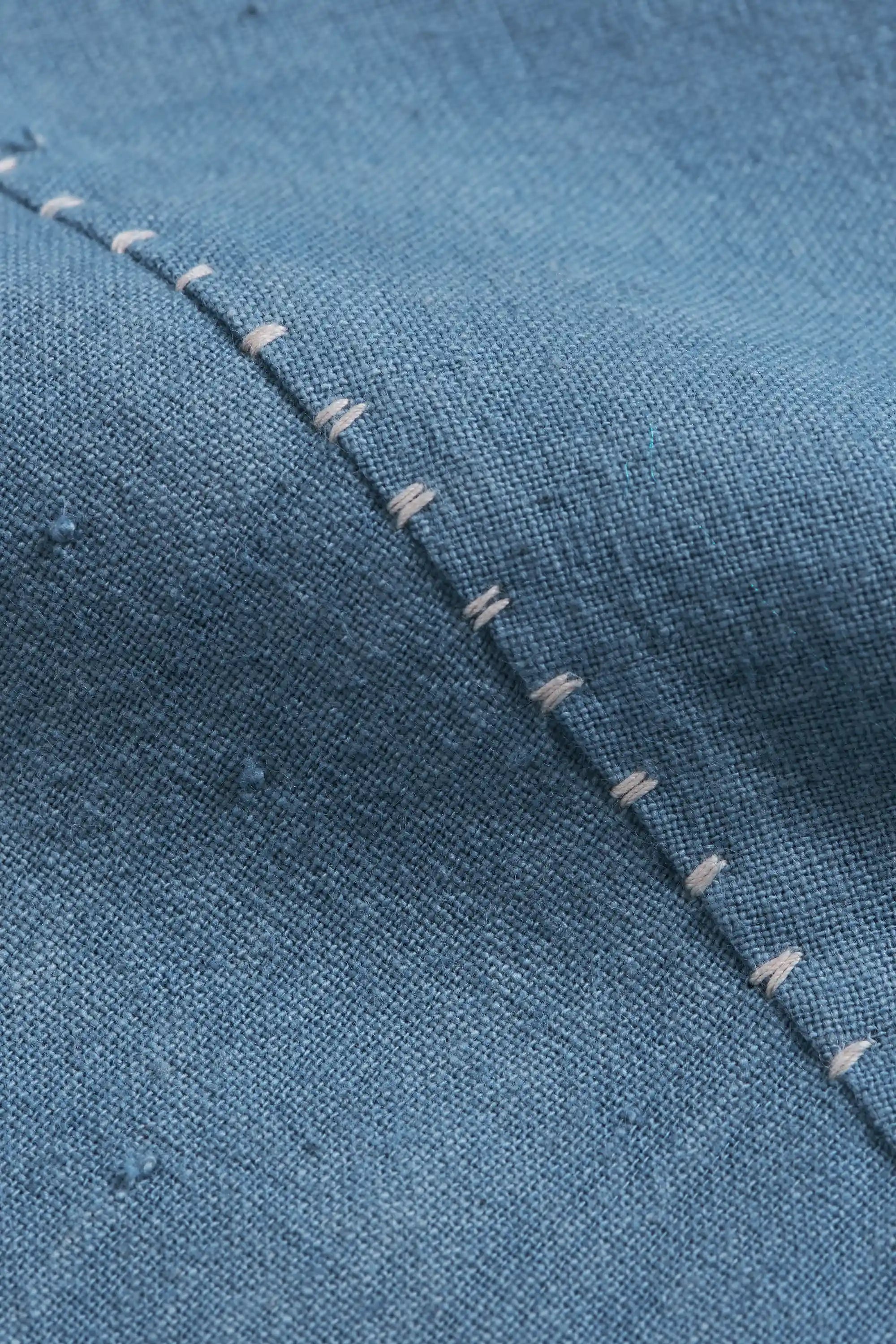 Close-up of blue cotton fabric with hand detailing