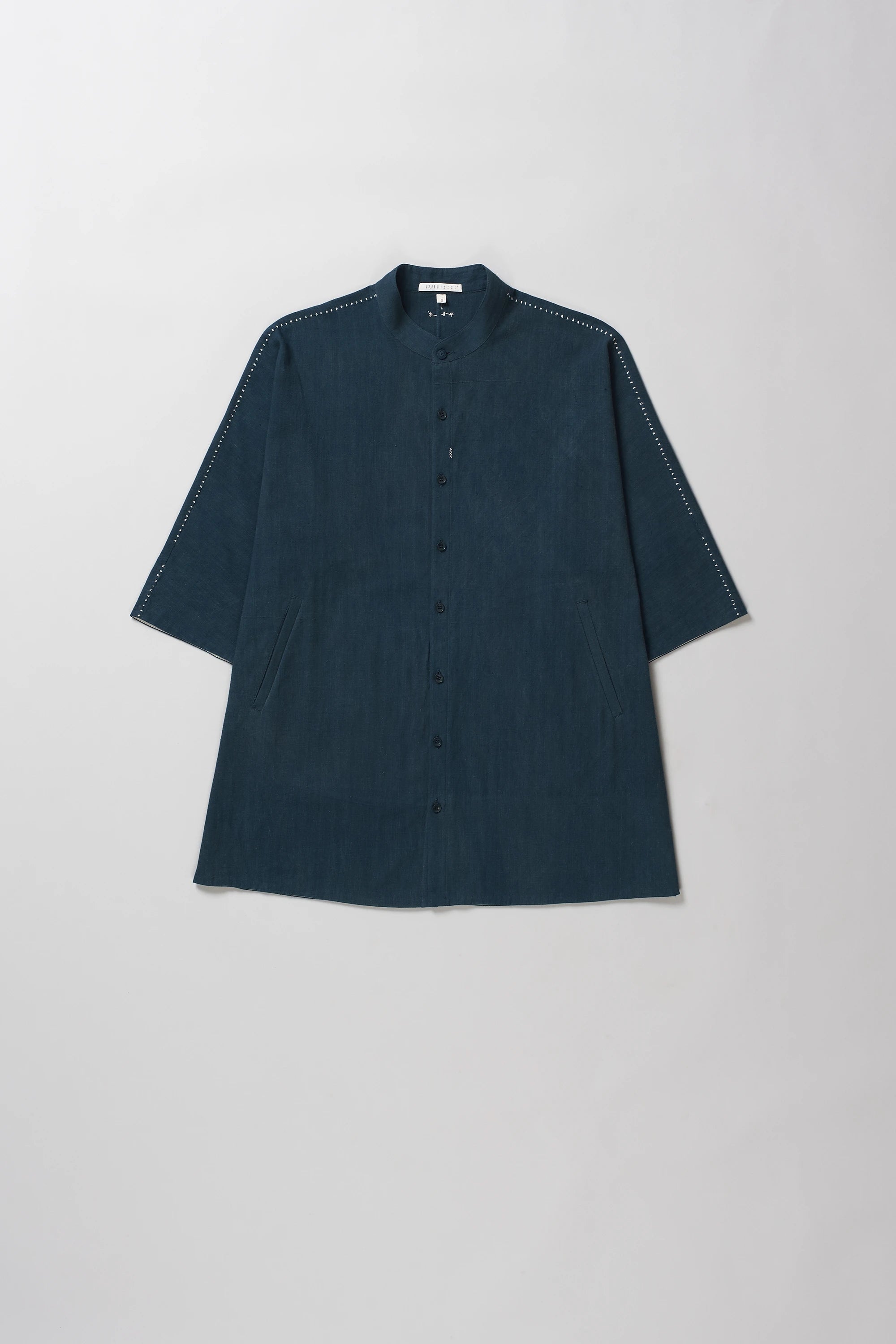 Black indigo half-sleeve button-up shirt with a band collar, laid flat against a light gray background.