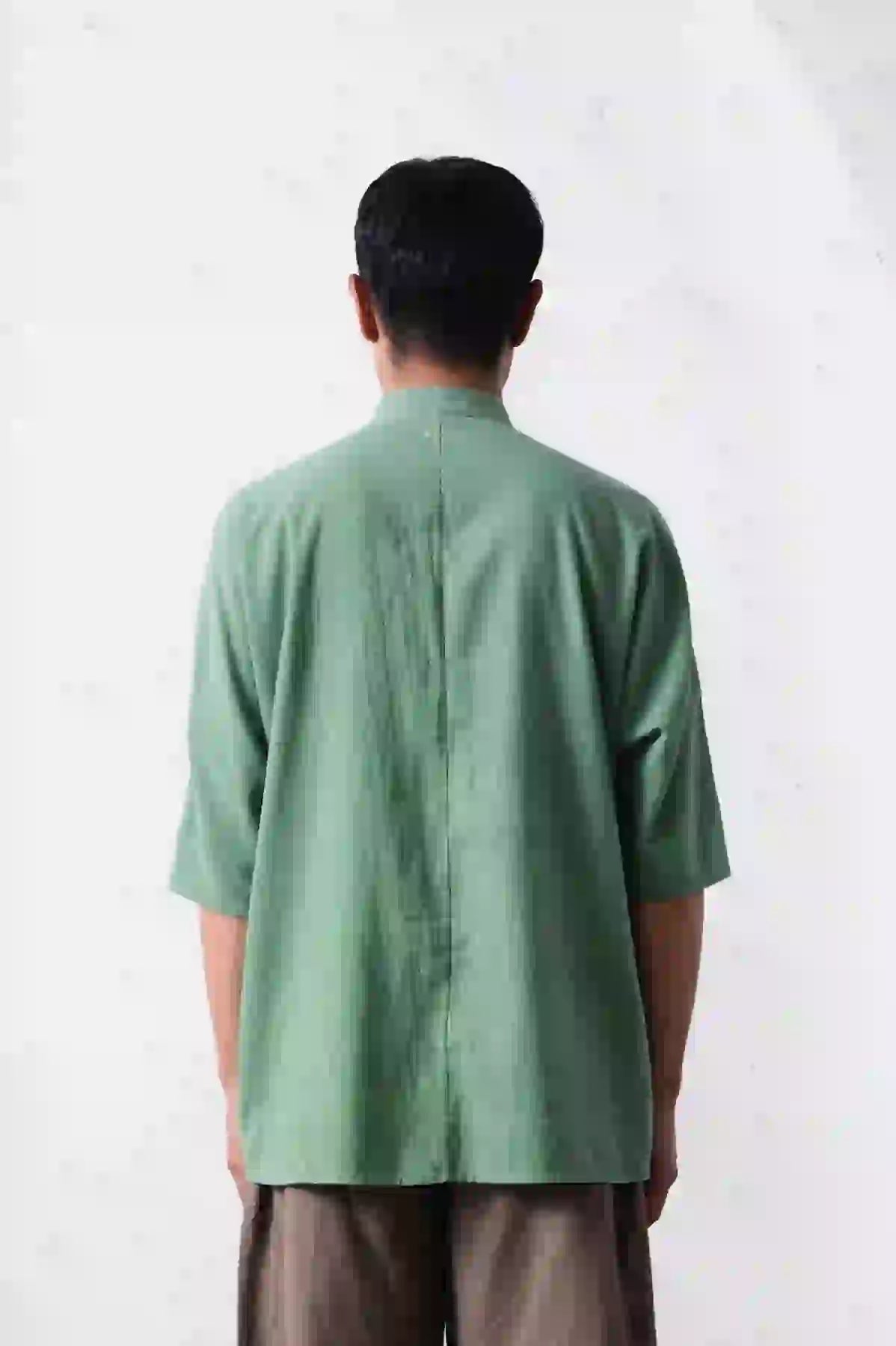 A back shot of man wearing macca shirt