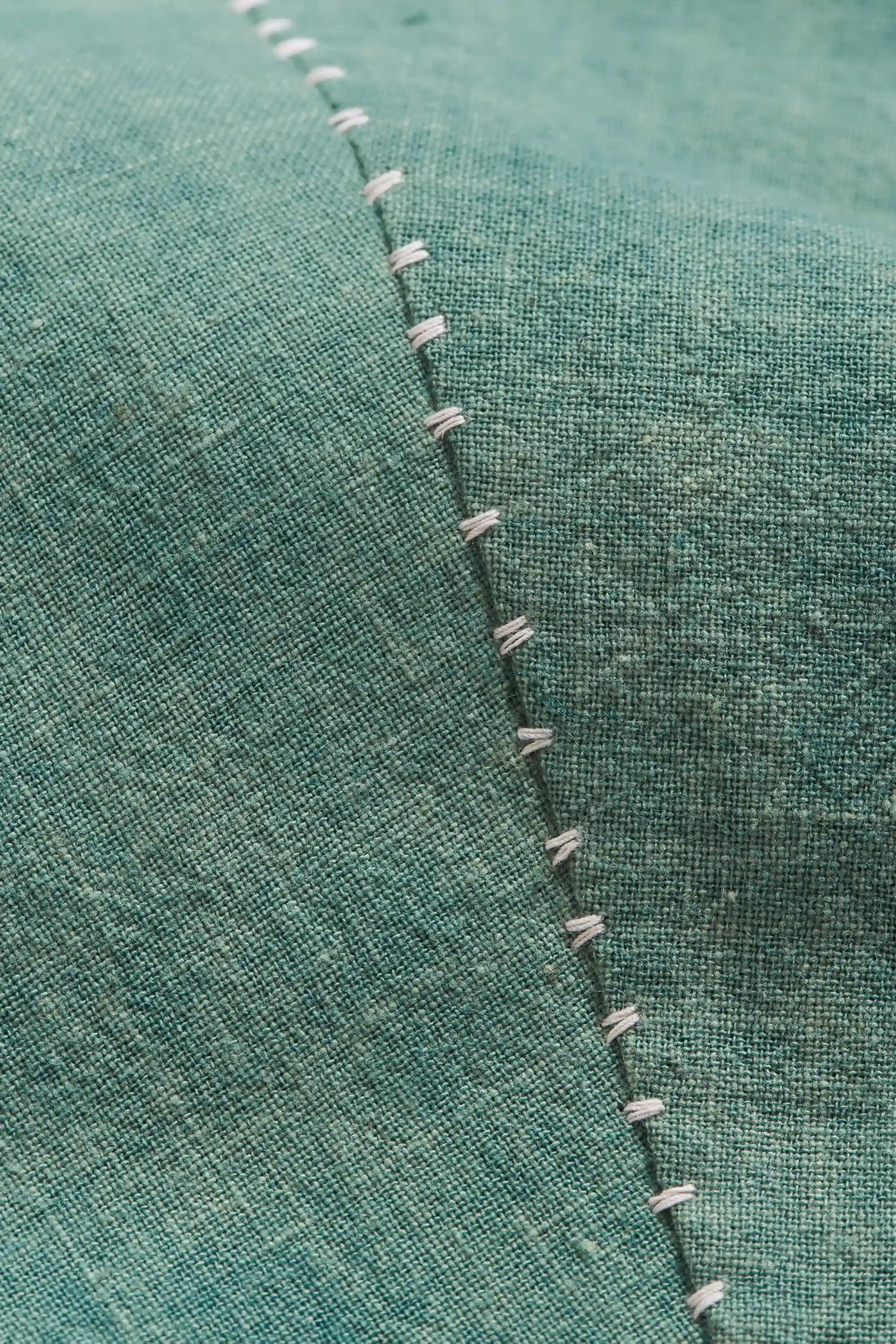 Close-up of a green fabric with hand detailing