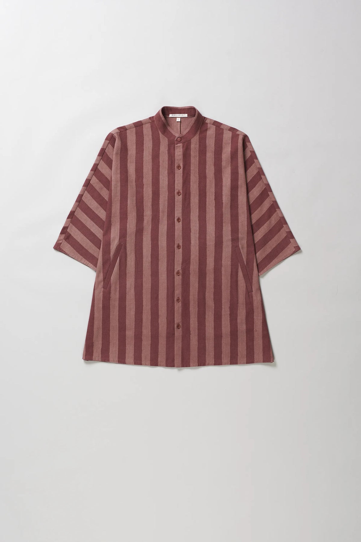 A short-sleeved button-up shirt with vertical stripes in dusty rose and dark brown, featuring a mandarin collar, laid flat against a light grey background.