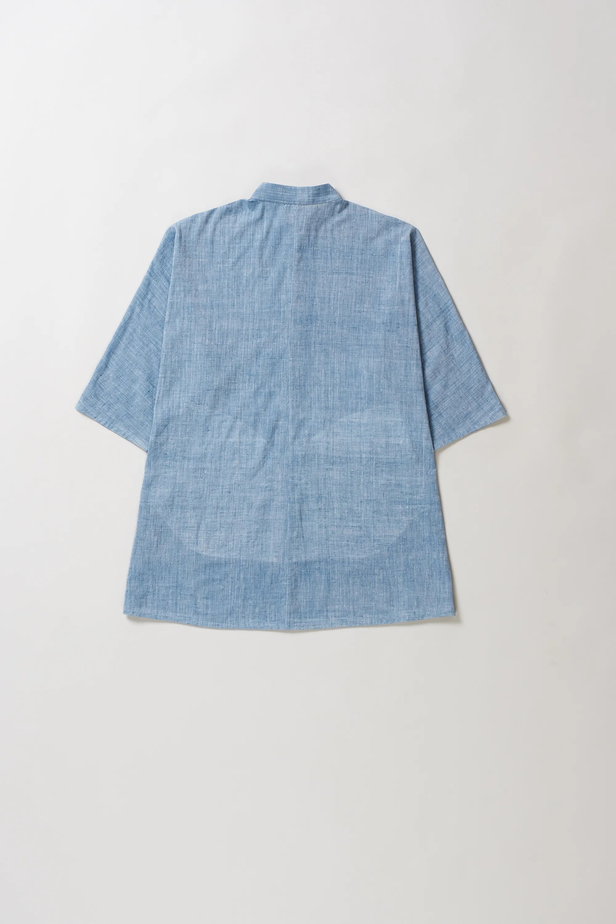 Back image of blue cotton shirt on a light grey background