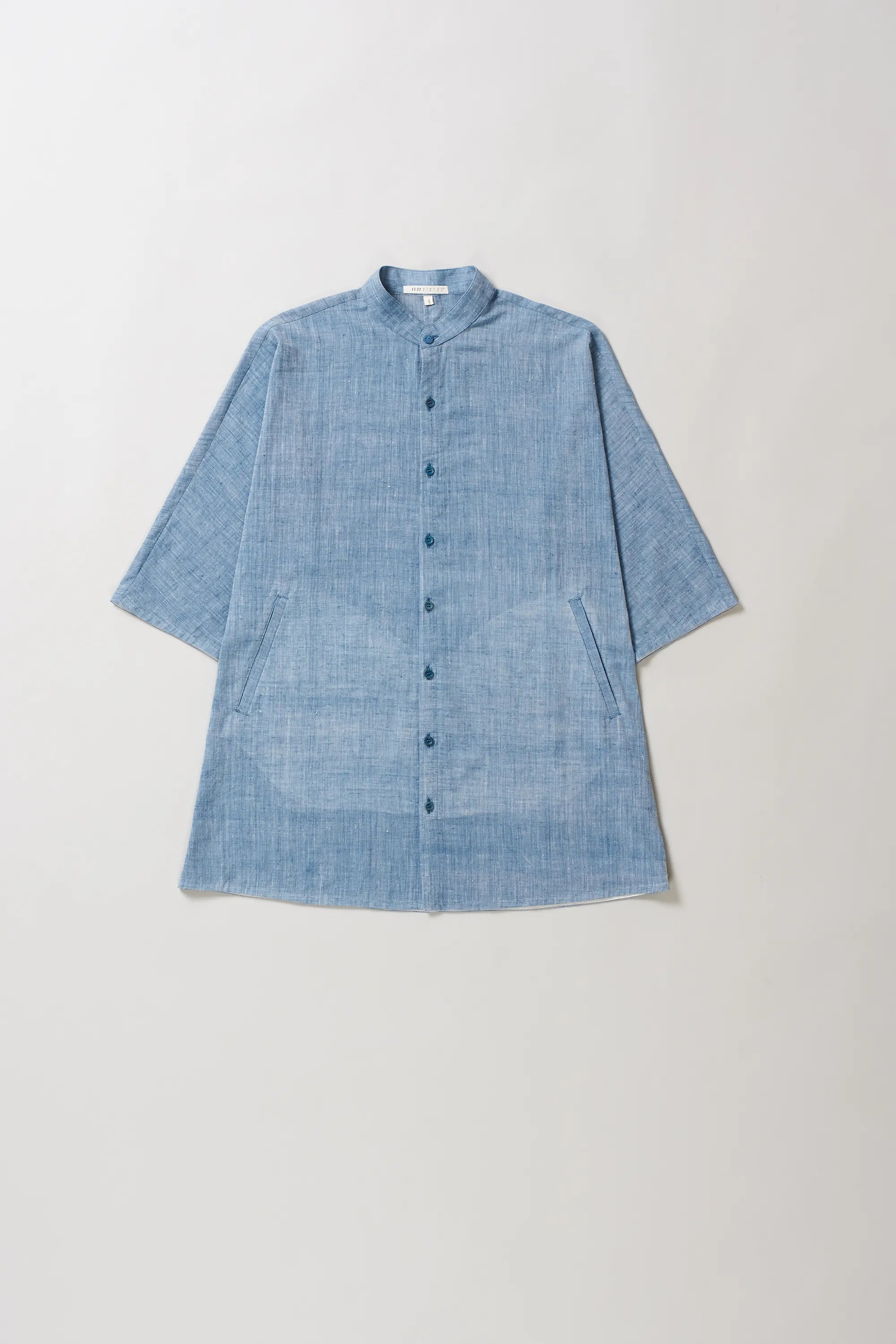Front image of blue cotton shirt on a light grey background