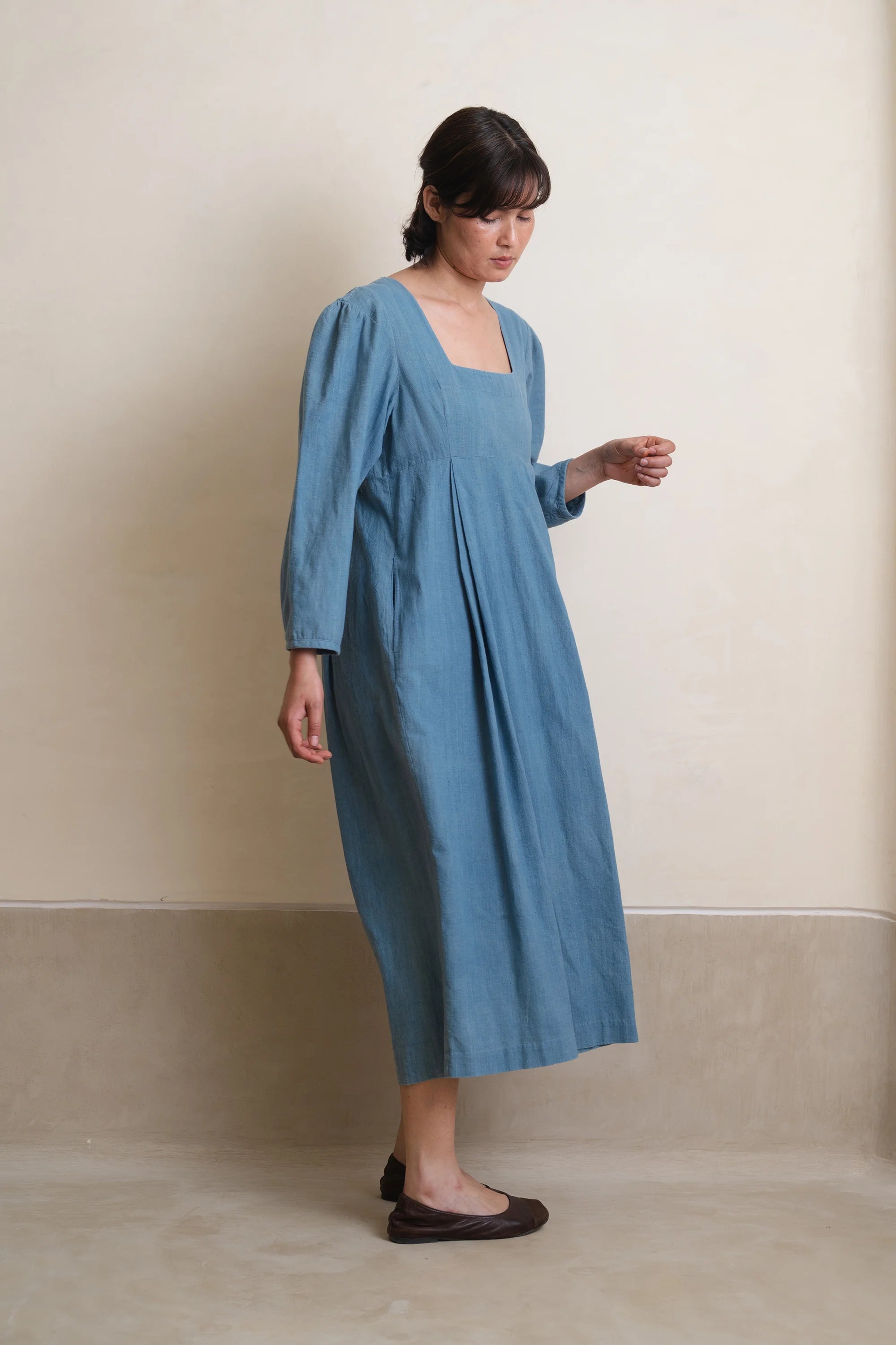 A side shot of a woman wearing powder blue dress