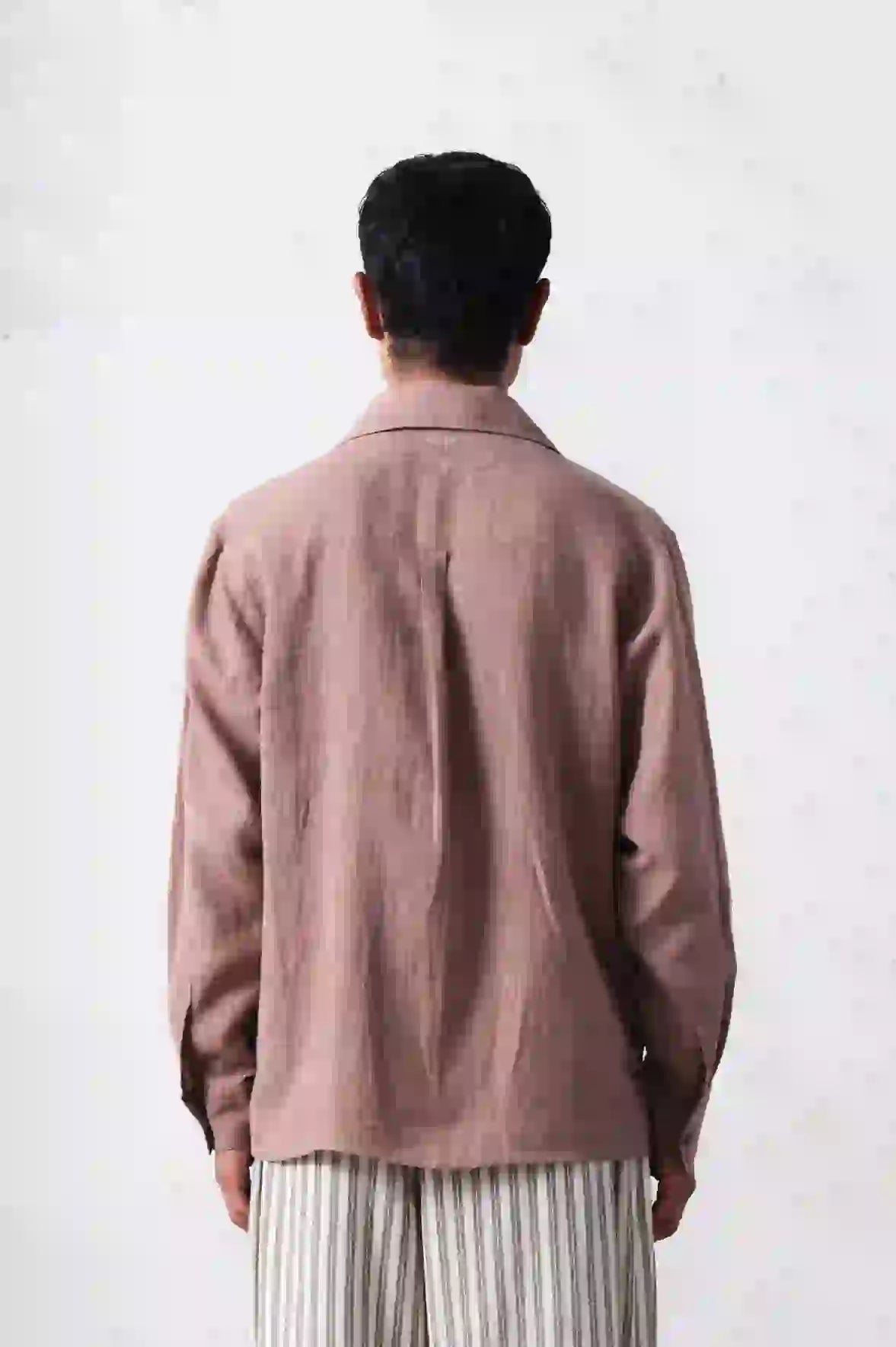 A back shot of man wearing old rose shirt