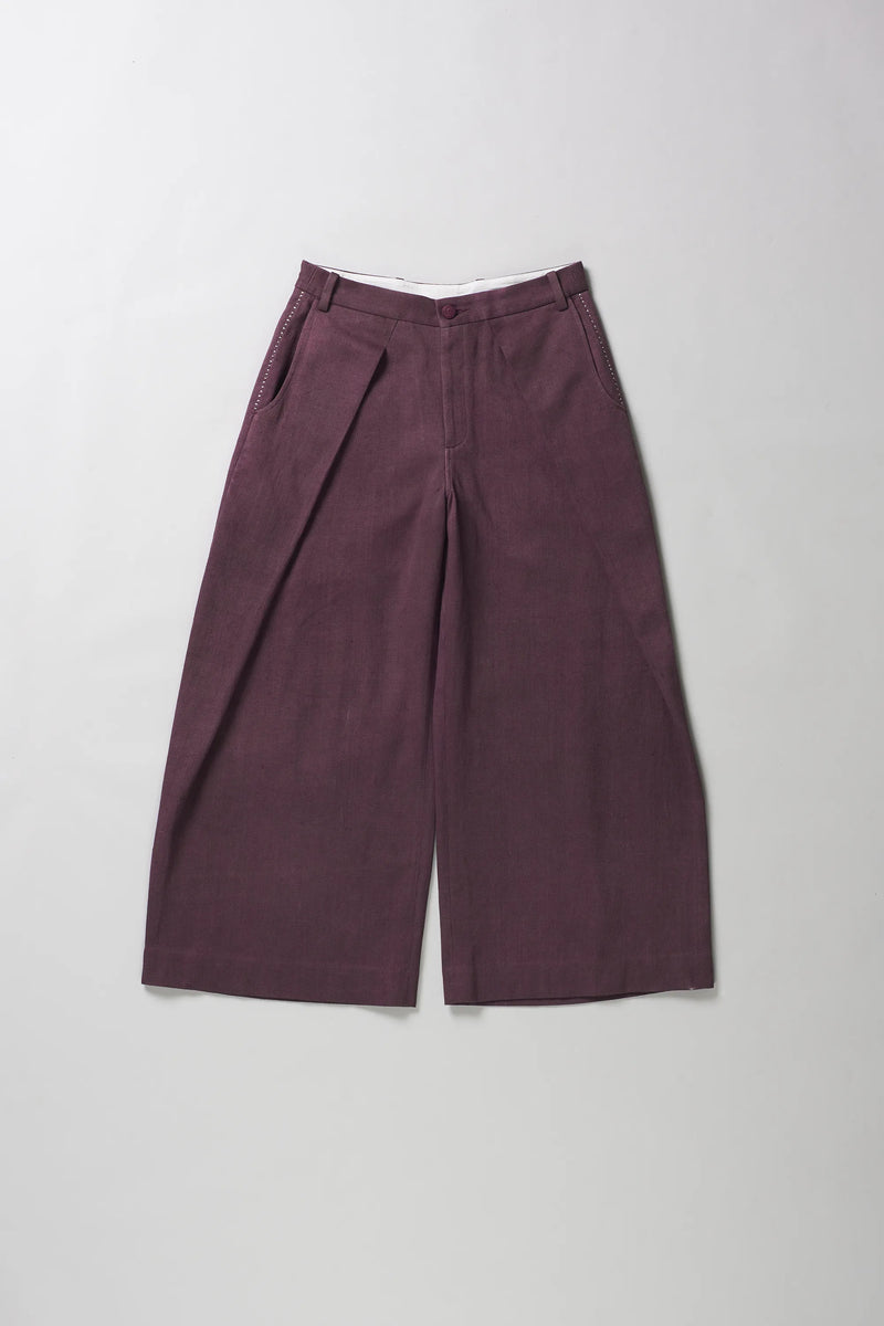 A pair of wide-leg trousers in a purple color, laid flat against a light grey background.