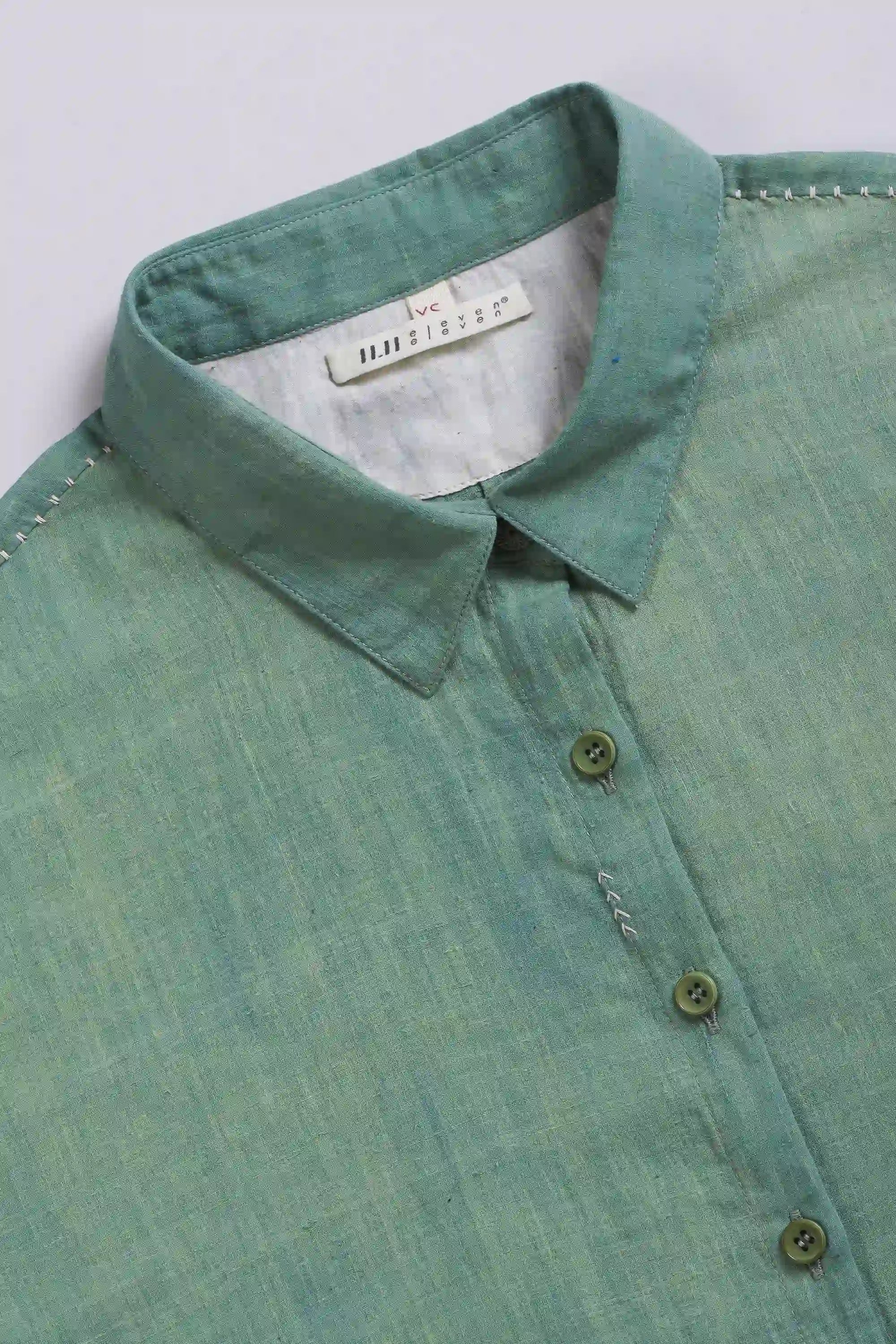 Green shirt with collar and buttons on a light grey background