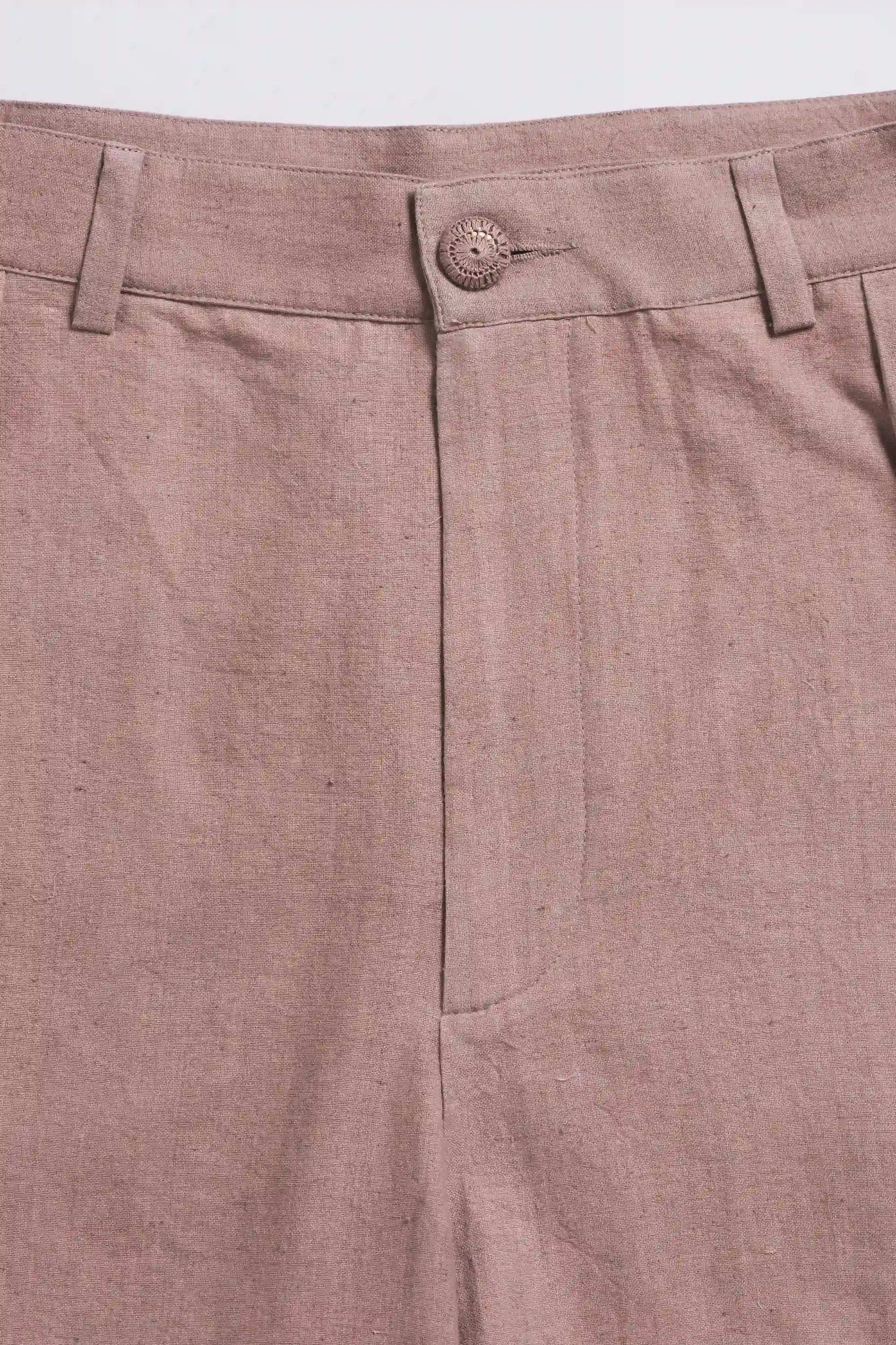 Close-up of old rose pleated pants with a button on a light grey background