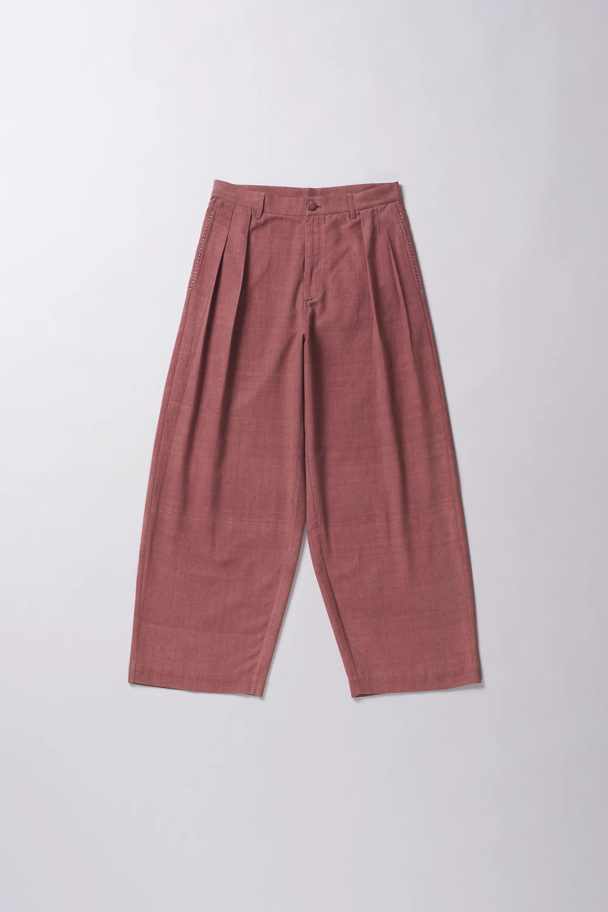 Rogue Pink pleated pants on a grey background