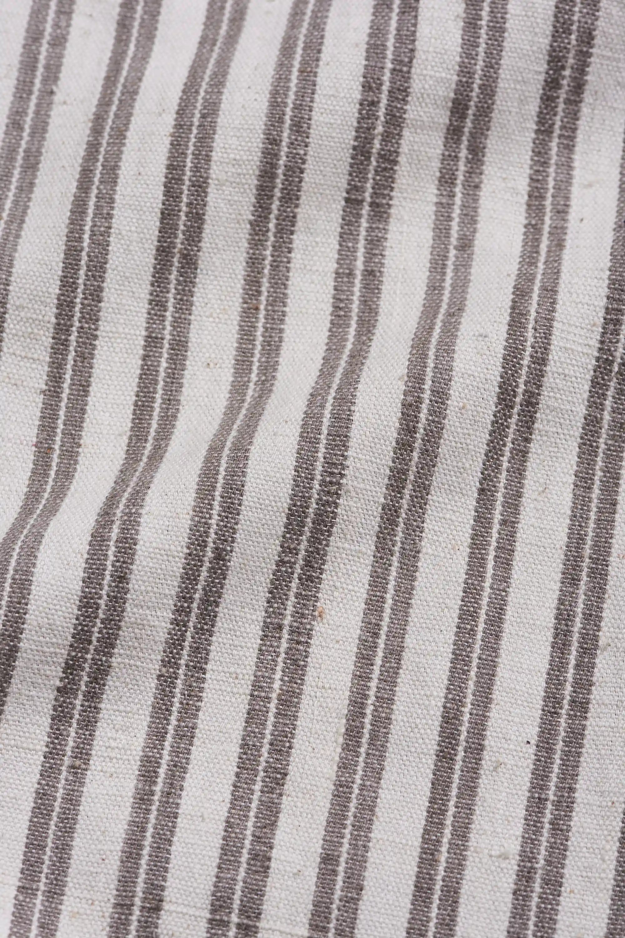 Close-up of fabric with wavy brown stripes on a light grey background