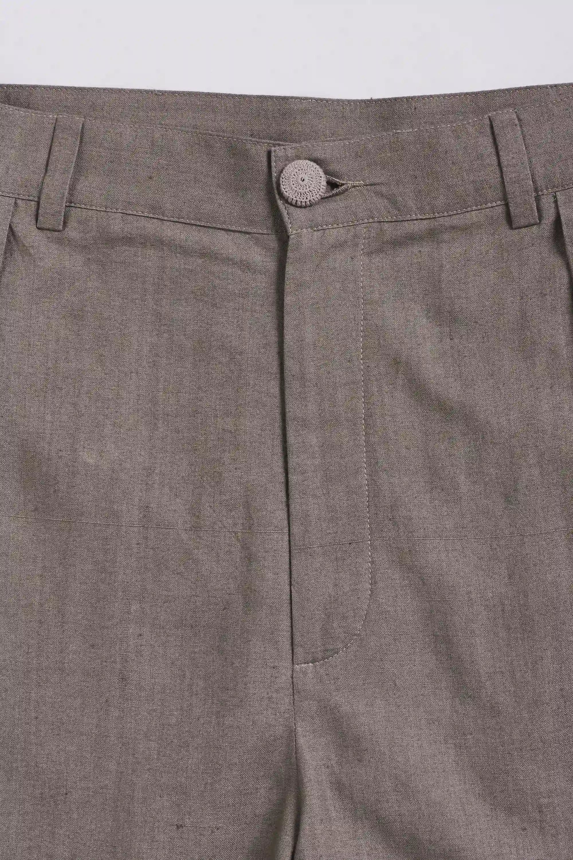 Close-up of ash grey pants with a button on a light grey background