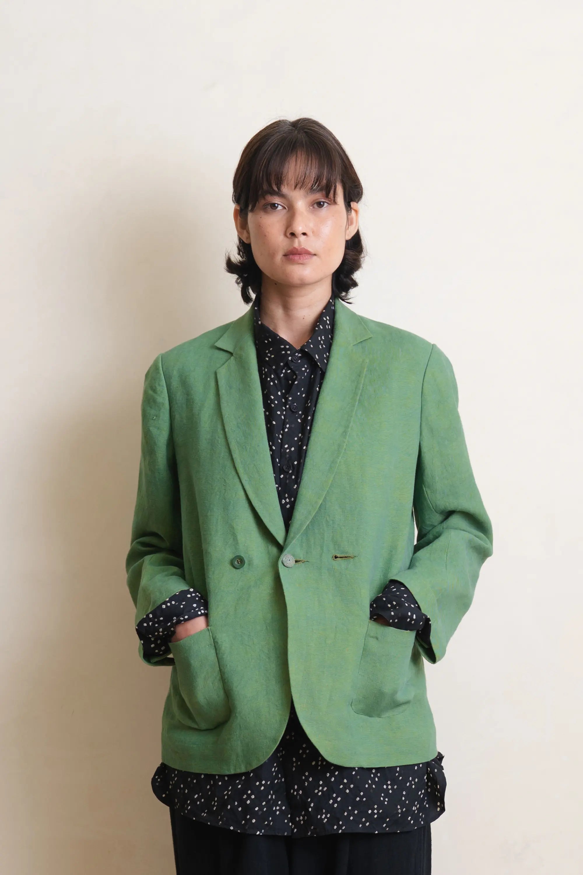 A woman wearing turf green linen jacket