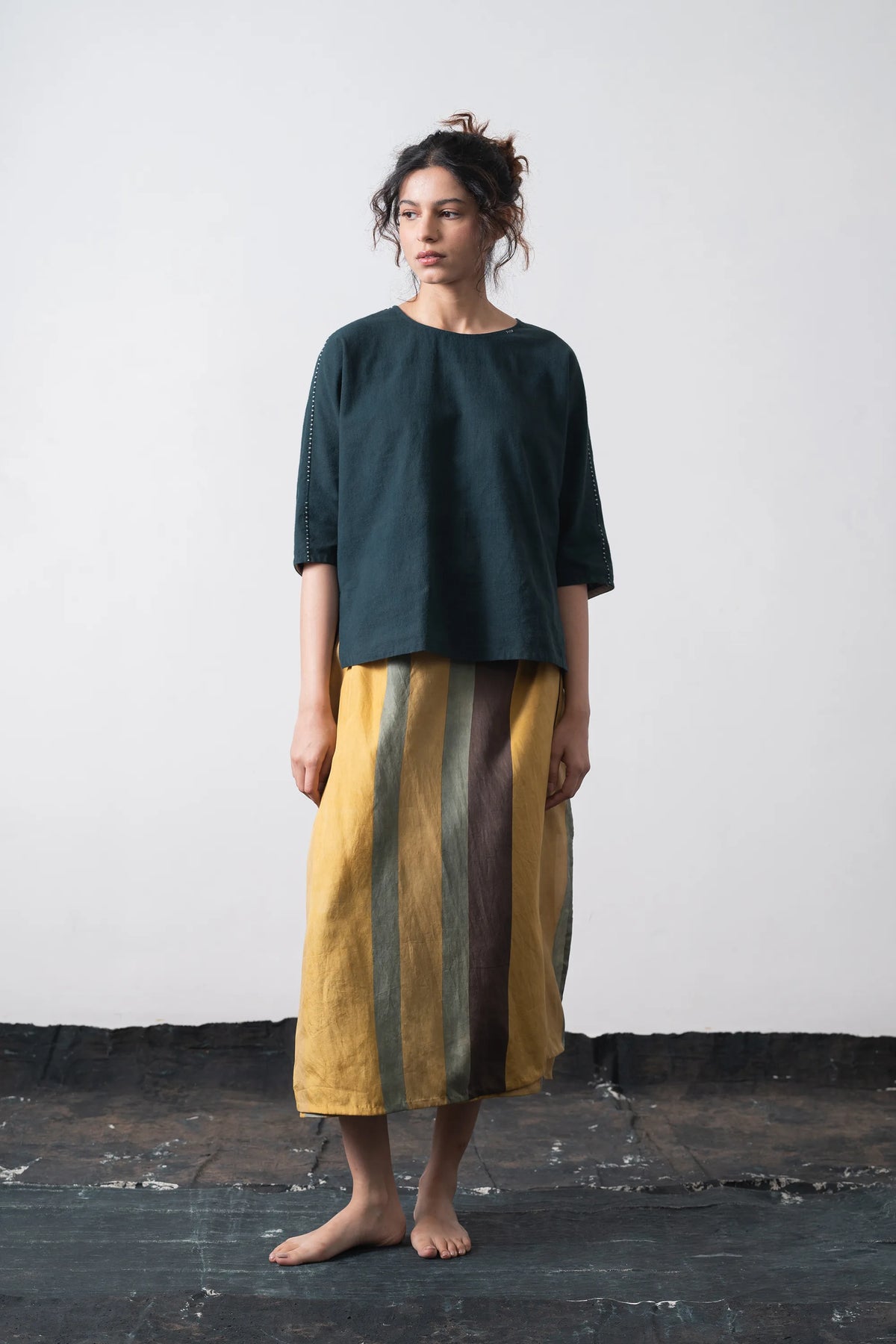 A woman wearing cotton black indigo top with hand details