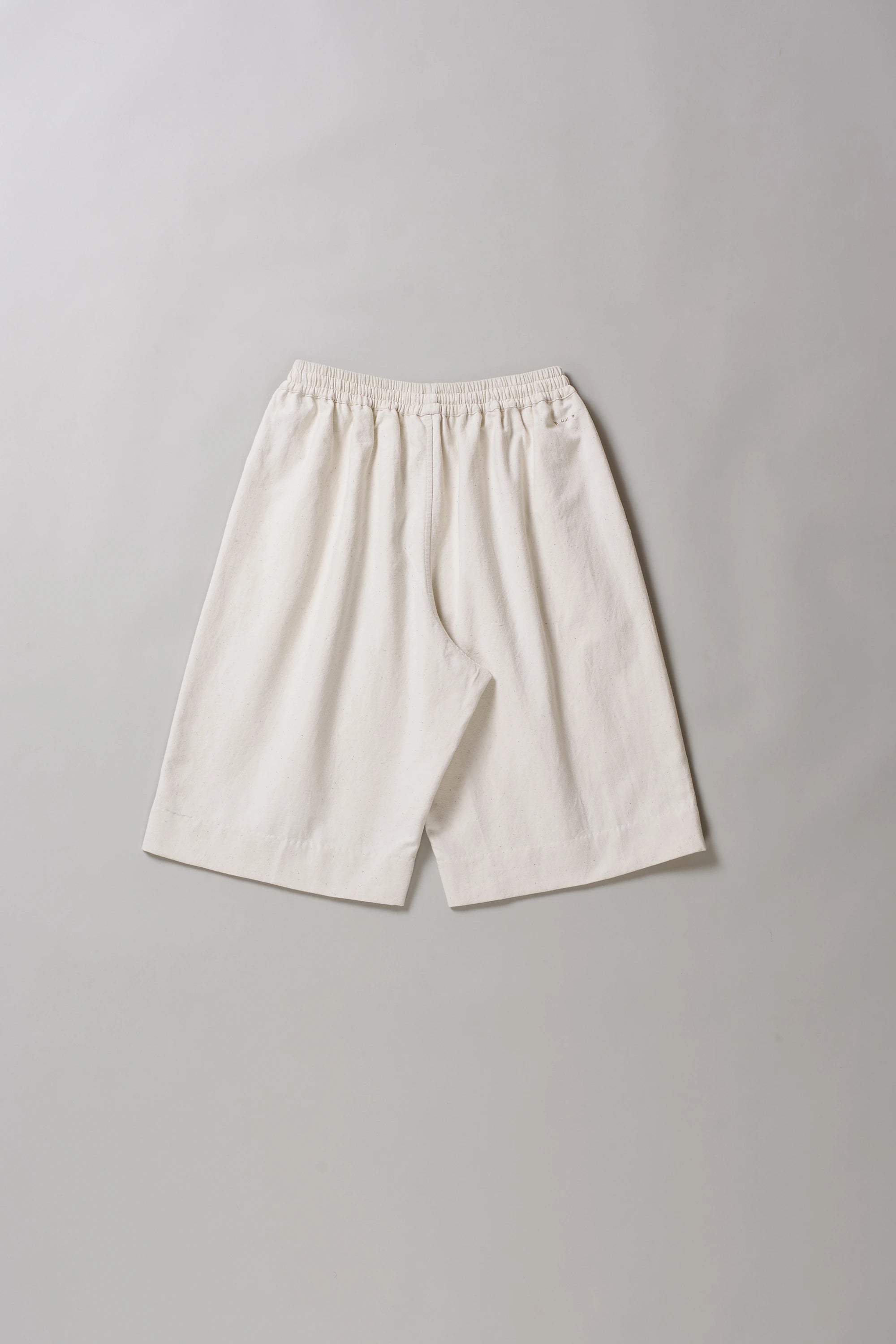 Ecru cotton shorts on a grey background