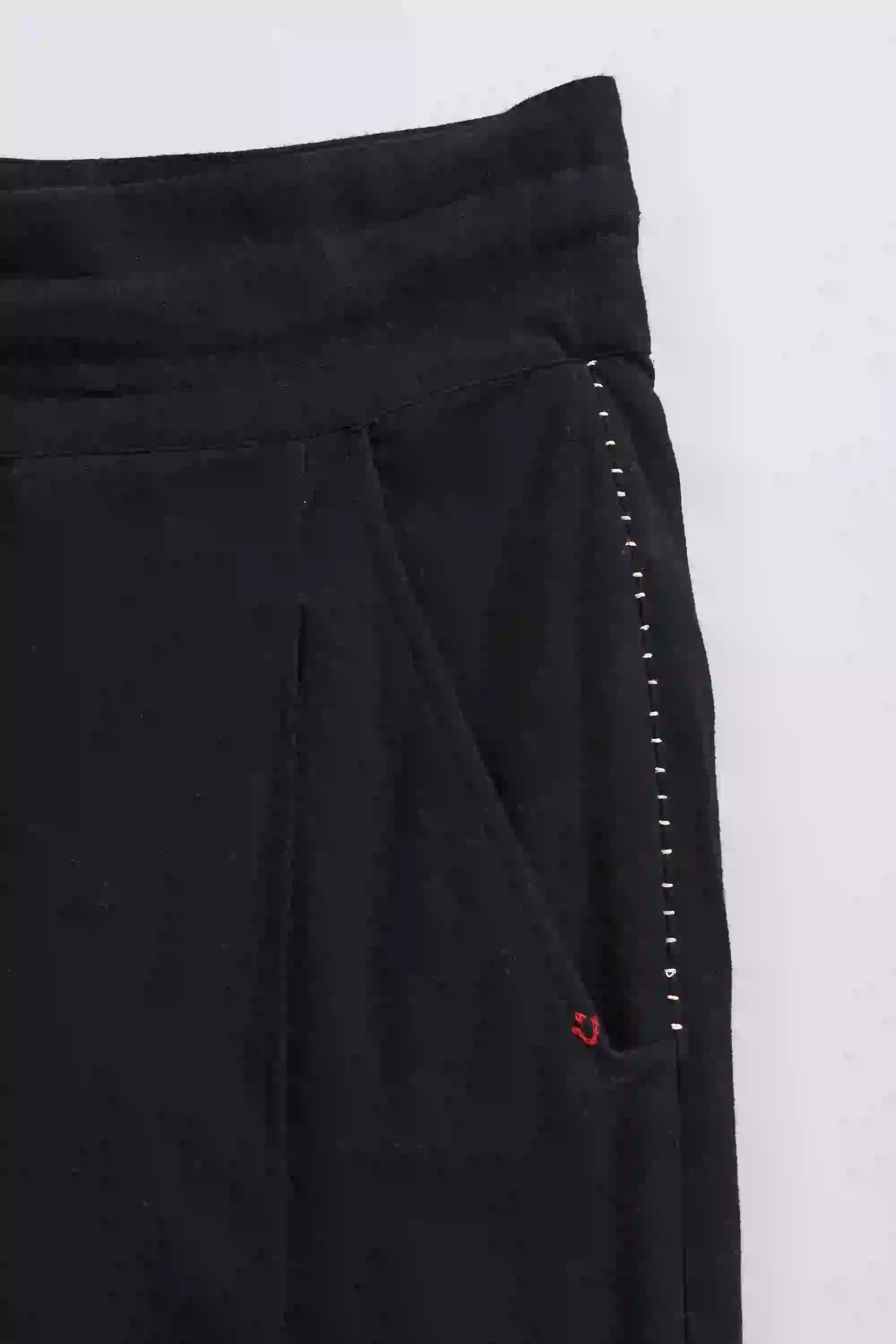 Black pants with white stitching detail on a white background