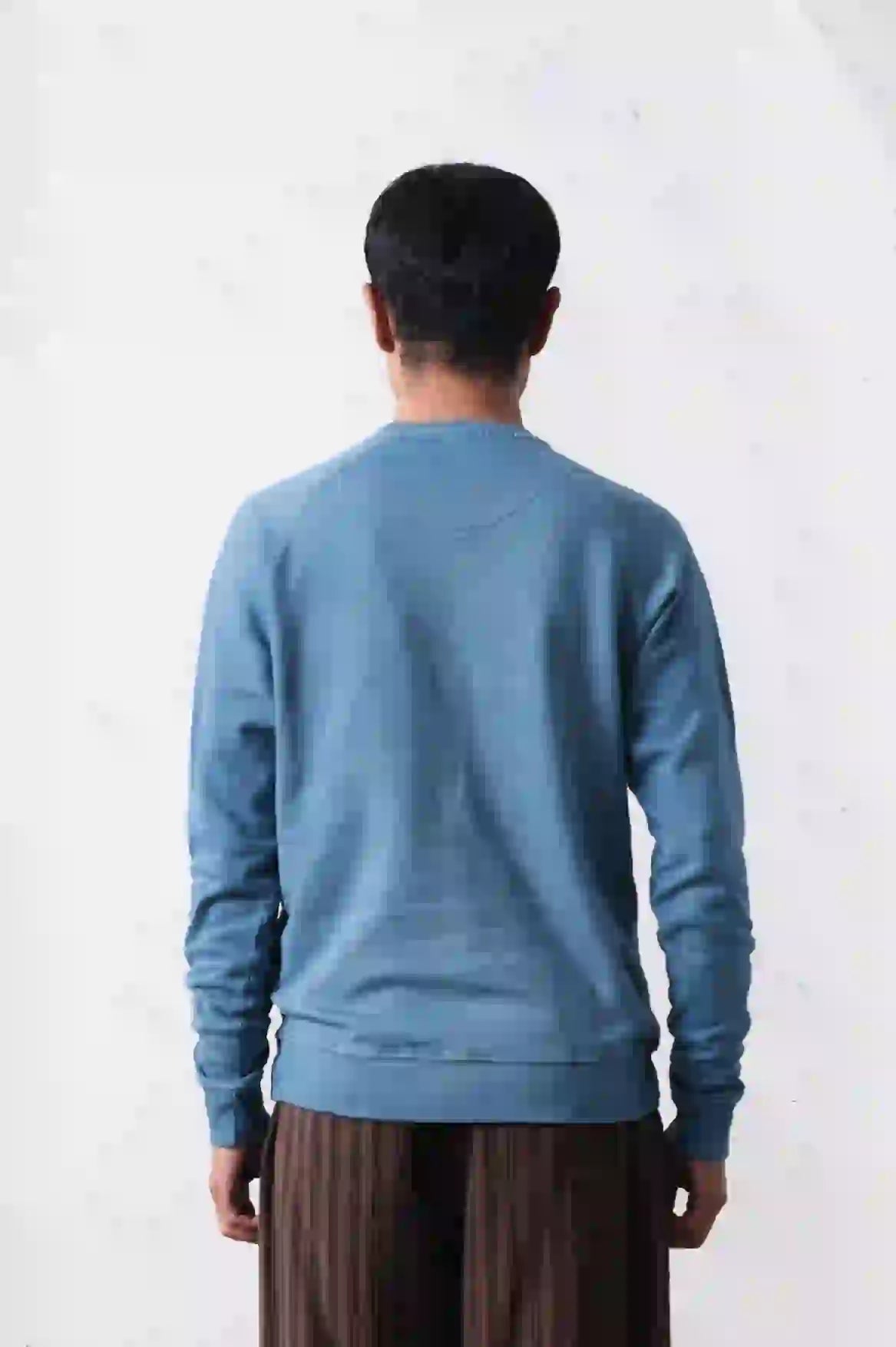 A man wearing powder blue sweatshirt